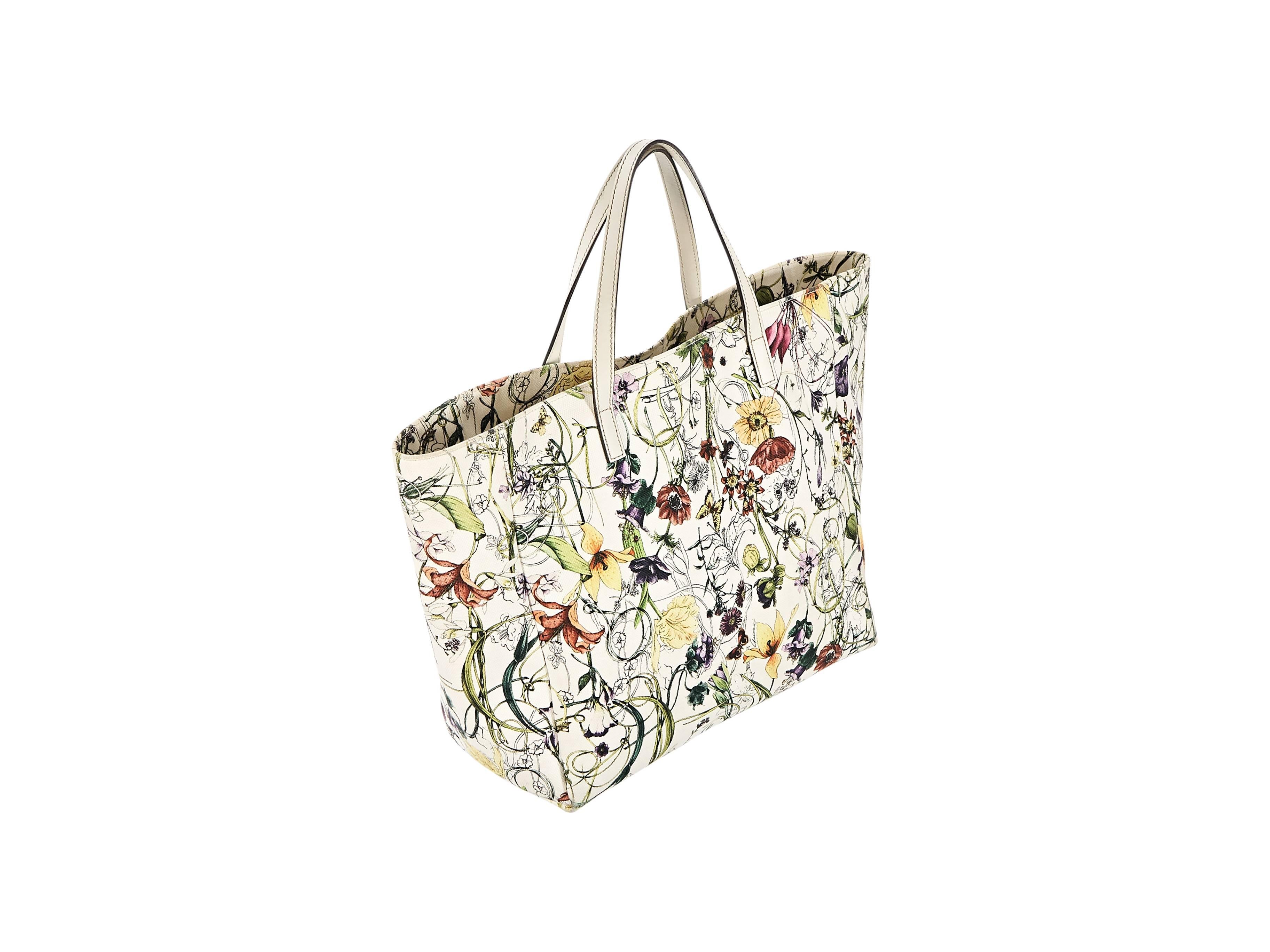 Product details:  Multicolor flora-printed Jolicoeur canvas tote bag by Gucci.  Top carry handles.  Open top.  Lined interior with inner zip and slide pockets.  12