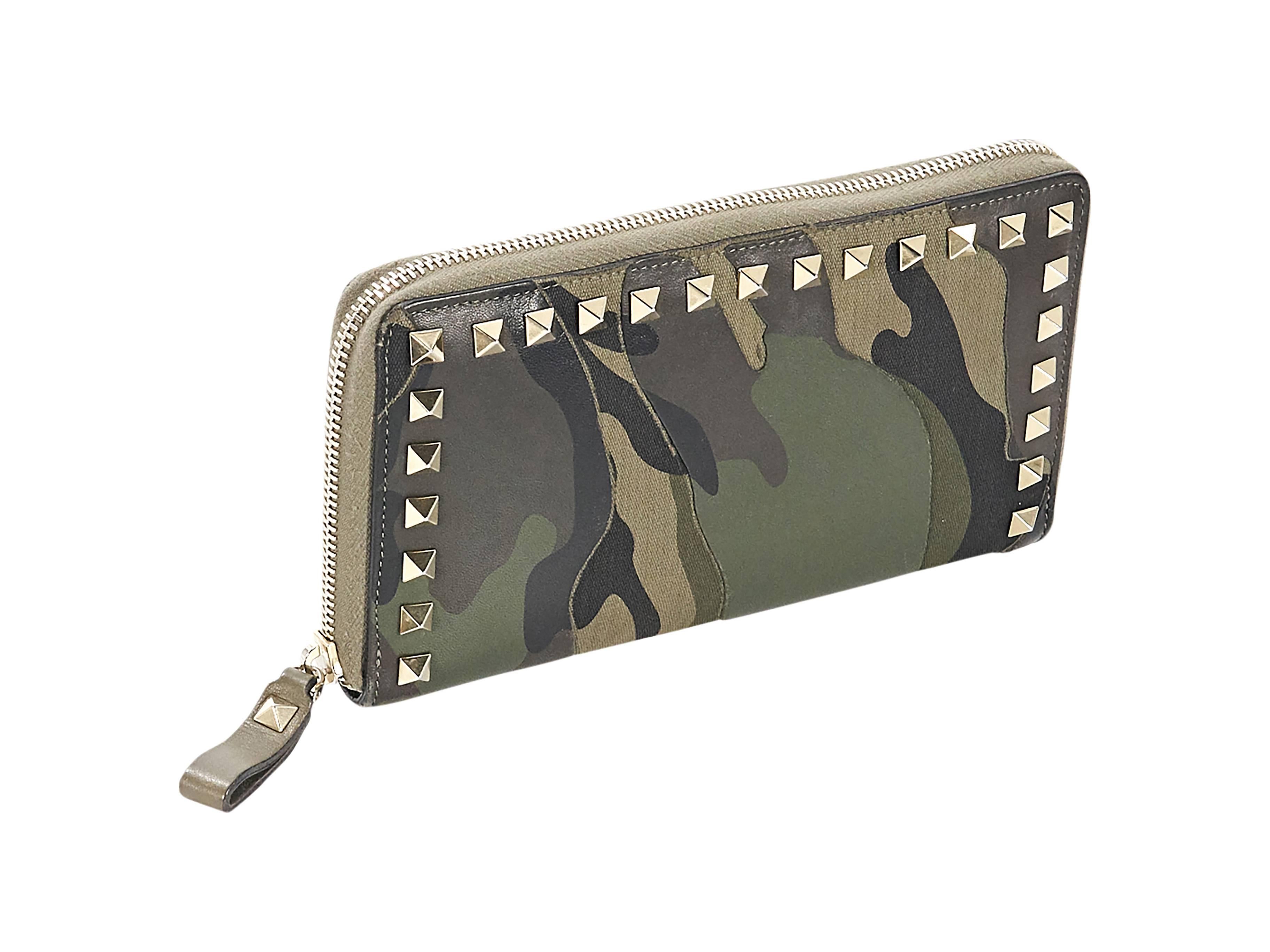 Product details:  Green camo Rockstud wallet by Valentino.  Zip-around closure.  Lined interior with multiple inner credit card slots, zip coin pouch and bill slots.  Goldtone hardware.  8