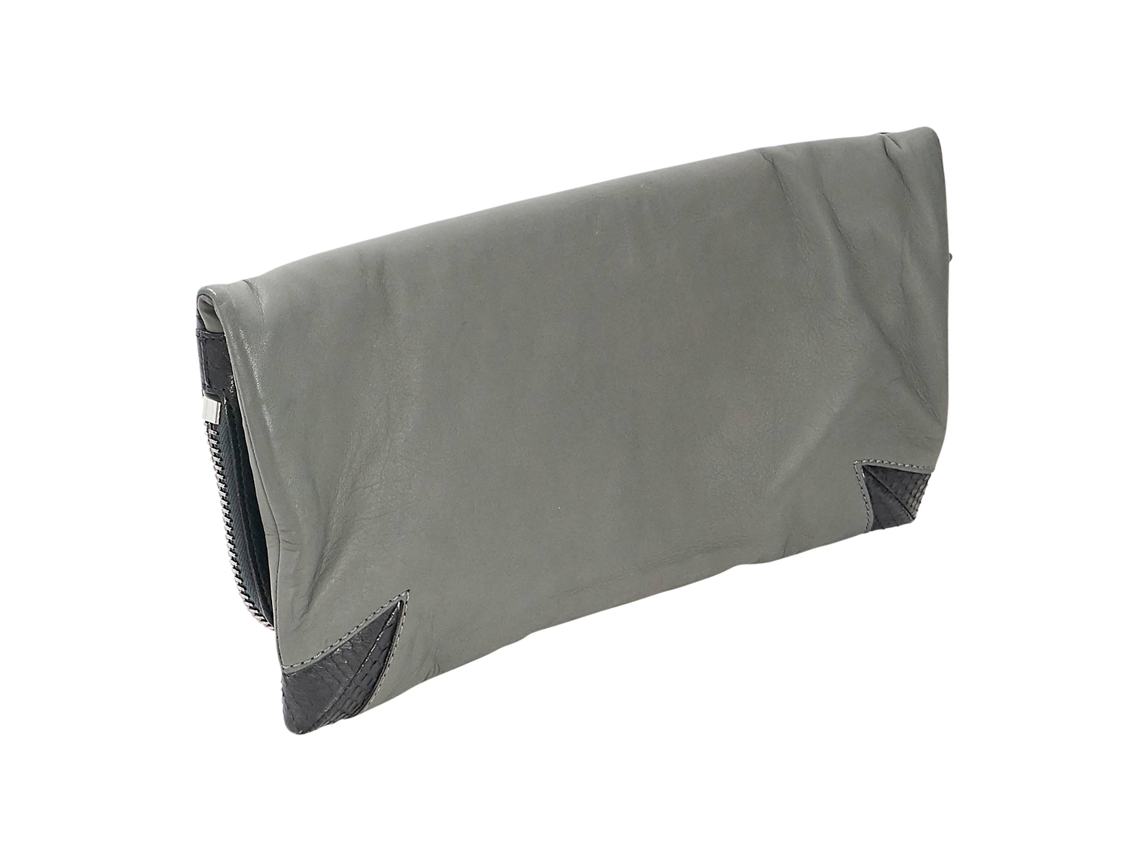 Product details:  Black and grey leather foldover clutch by Devi Kroell.  Front flap with zip closure.  Zip pocket over front flap.  Lined interior with inner zip pocket.  Silvertone hardware.  15
