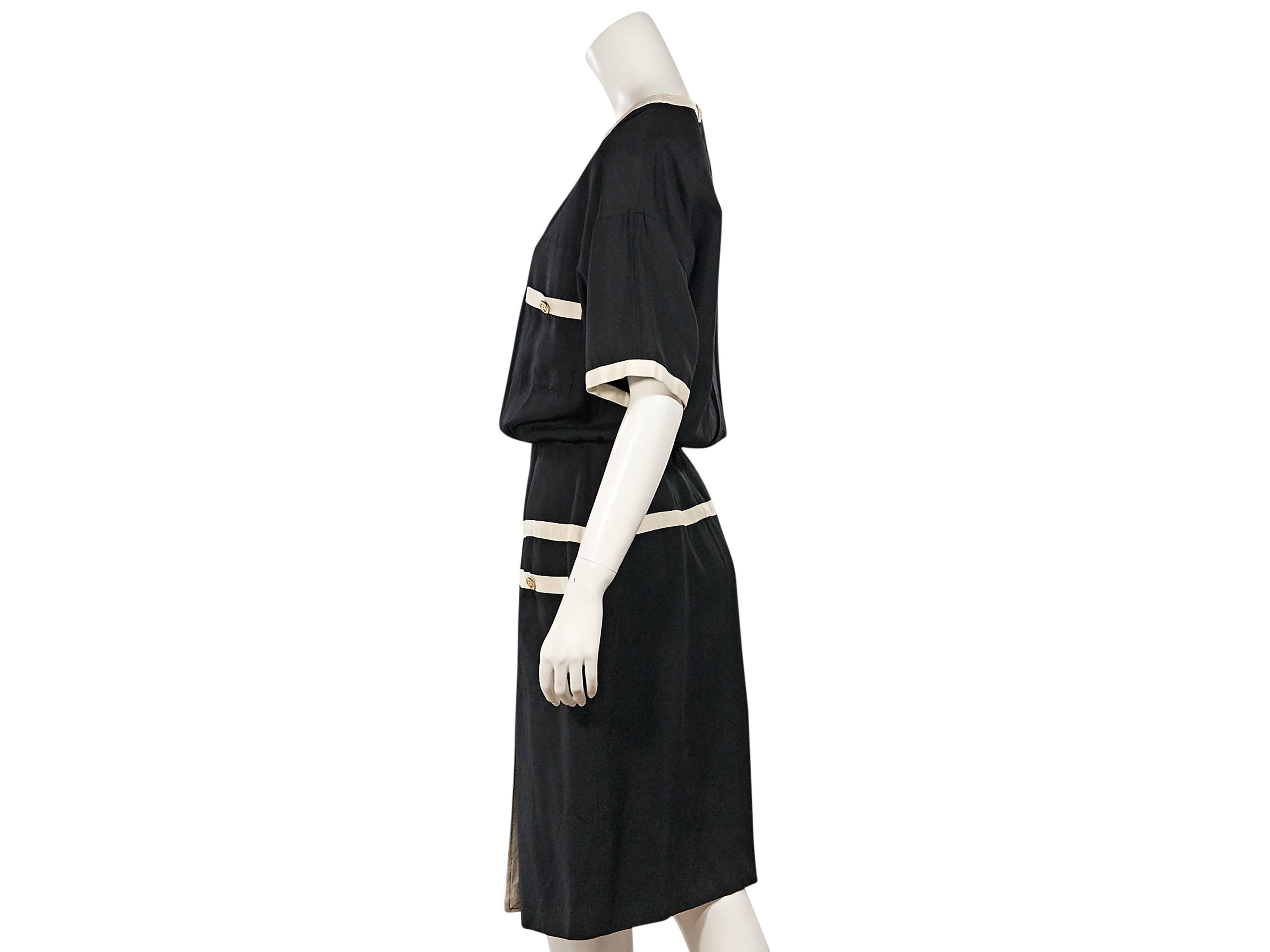 Product details:  Vintage black and white blouson dress by Chanel.  Split jewelneck.  Short sleeves.  Four front button patch pockets.  Front hem vent.  Back button closure.  
Condition: Excellent. 
Est. Retail $ 1,295.00