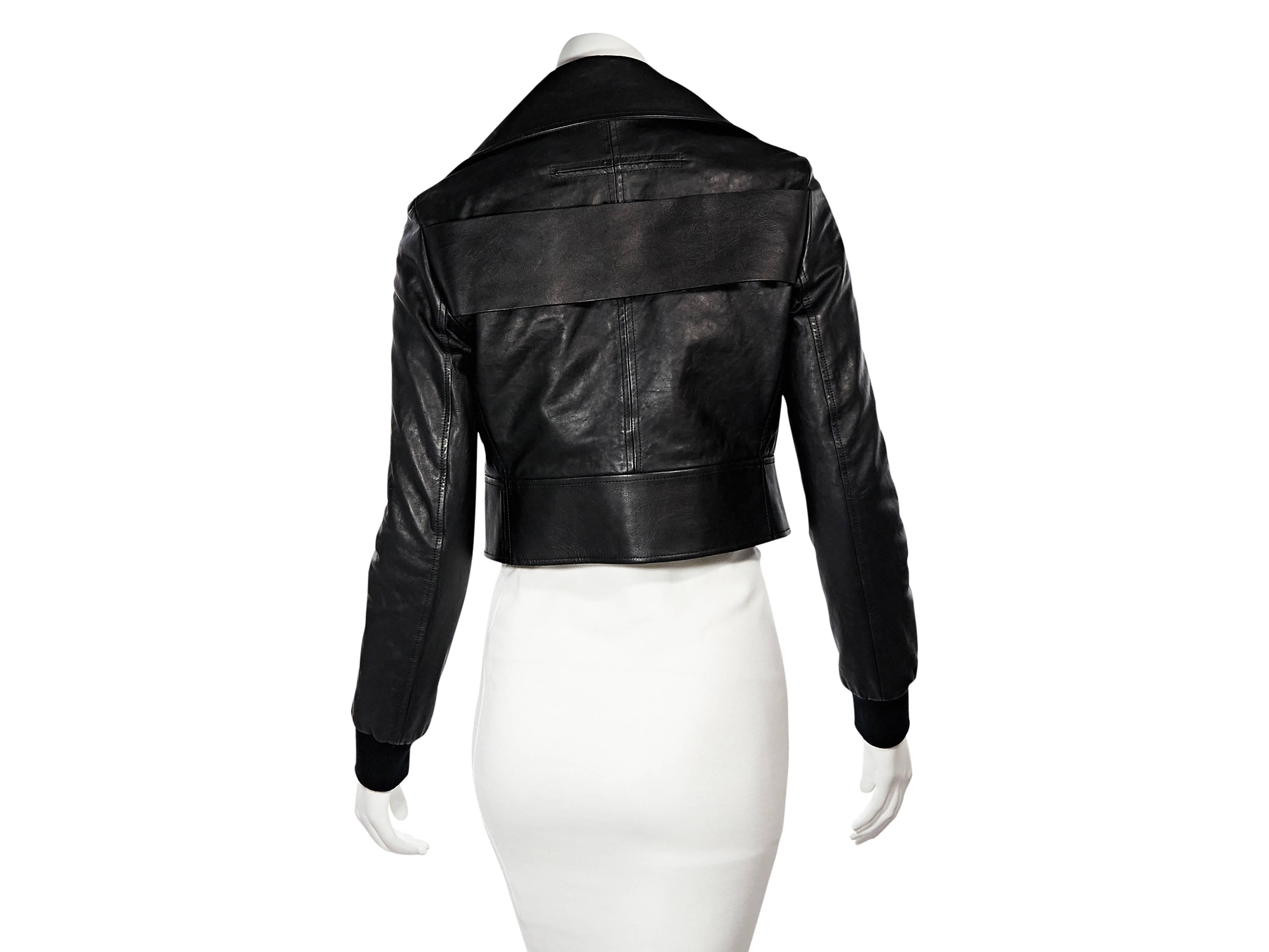 Product details: Black leather cropped jacket by Givenchy. Oversized notched lapel. Long sleeves. Ribbed cuffs. Asymmetrical zip-front closure. Snap flap pockets. Wide back strap accent. Banded hem with concealed snap closure. 
Condition: Very good.