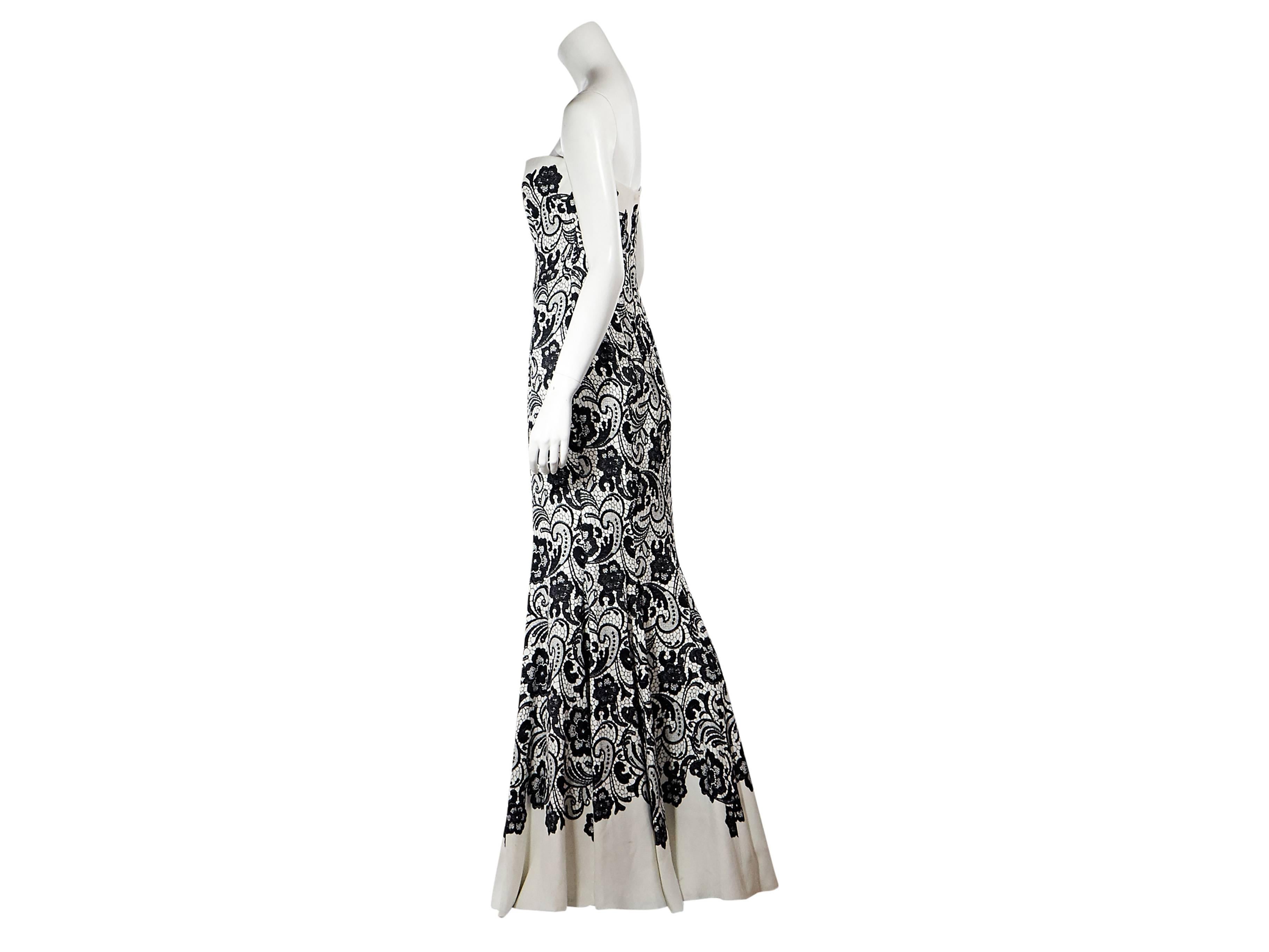 Product details: White and black strapless floral lace gown by Dolce & Gabbana. Formfitting silhouette. Concealed back zip closure. Inner boned corset for structure. Label size IT 42. 
Condition: New with tags. 
Est. Retail $ 6,225.00