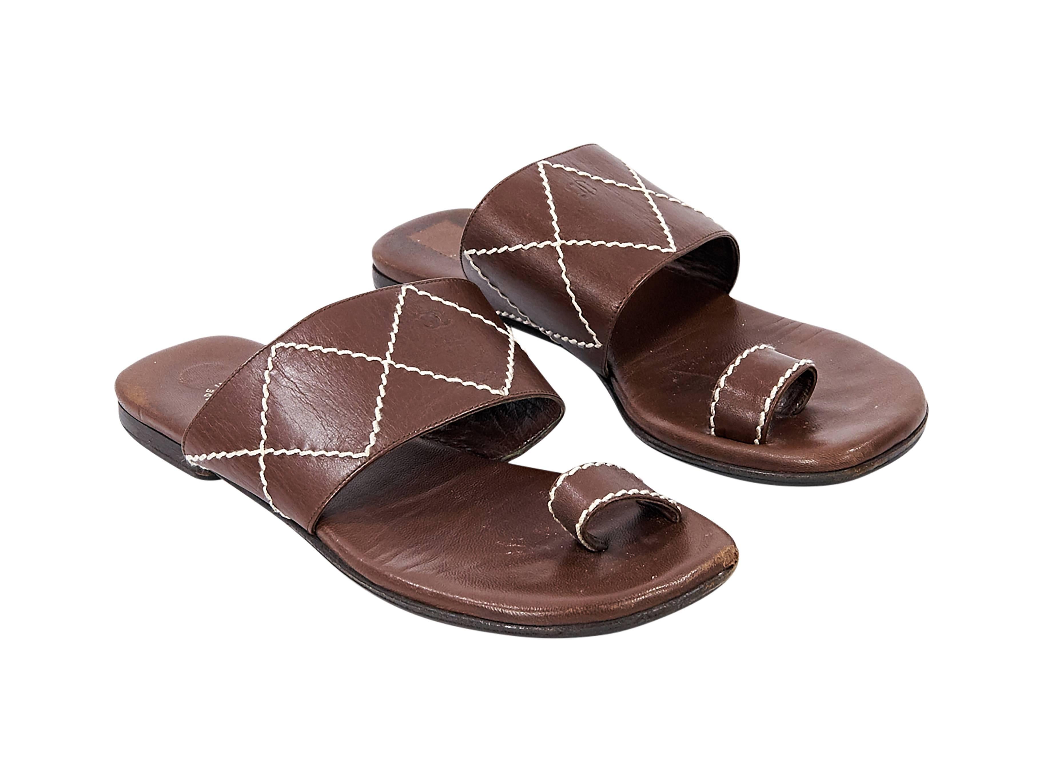Product details: Brown leather flat sandals by Chanel. Accented with white topstitching. Toe ring. Slip-on style. 
Condition: Good. 
Est. Retail $ 1,245.00