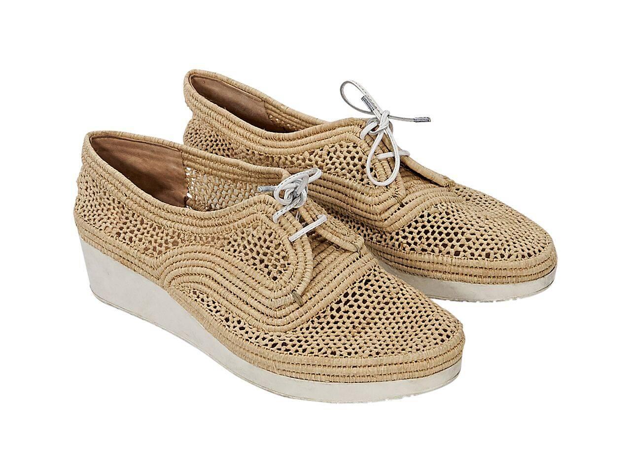 Product details:  Tan woven raffia wedge sneakers by Robert Clergerie.  Lace-up closure.  Round toe. 
Condition: Pre-owned. Very good.
Est. Retail $ 698.00
