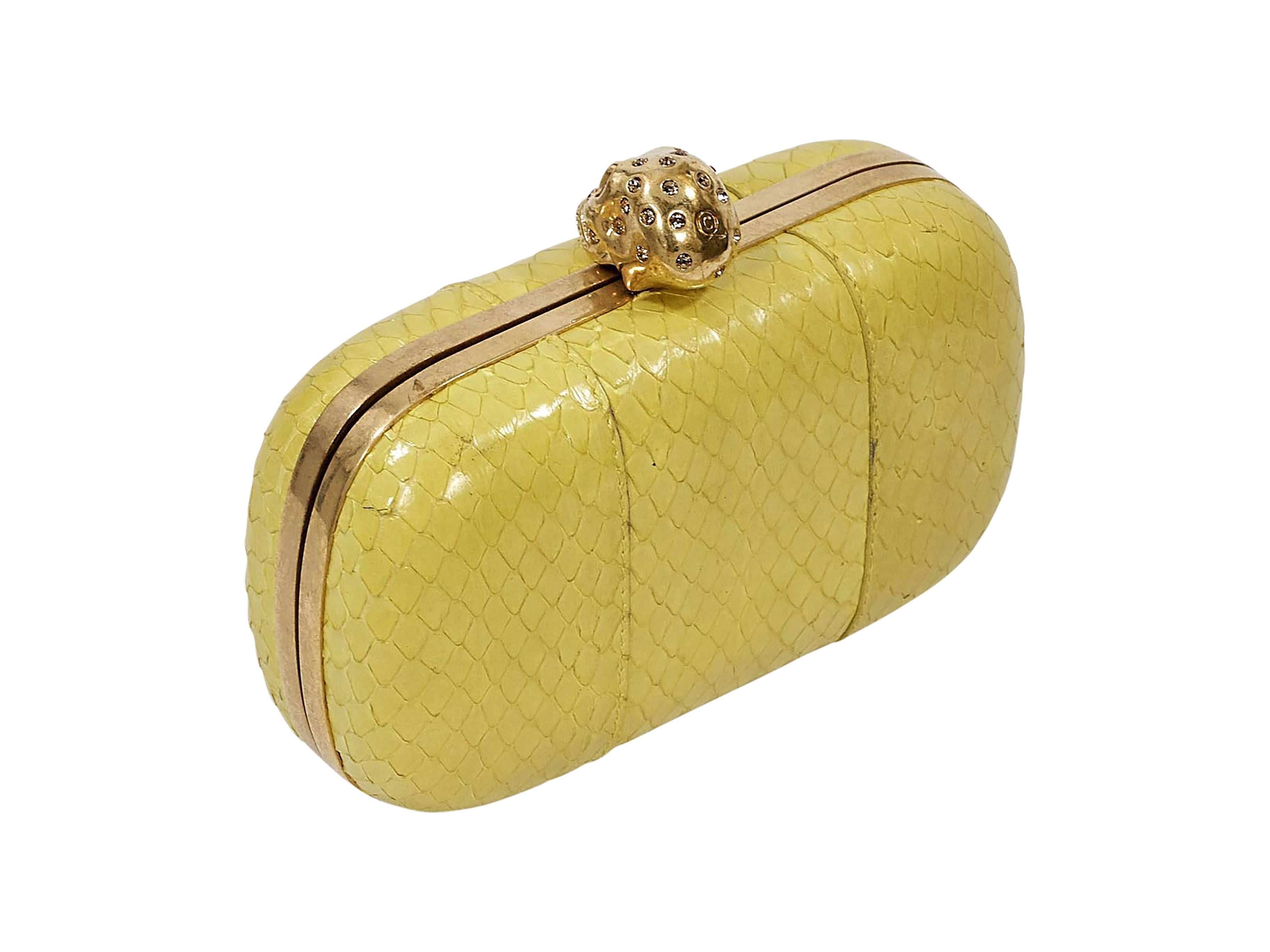 Product details:  Yellow small box clutch by Alexander McQueen.  Embellished skull push-lock closure.  Lined interior.  Gold-tone hardware.  6.5"L x 3.5"H x 2.25"D.
Condition: Pre-owned. Good.  Exterior scratches and pen marks. 

Est.