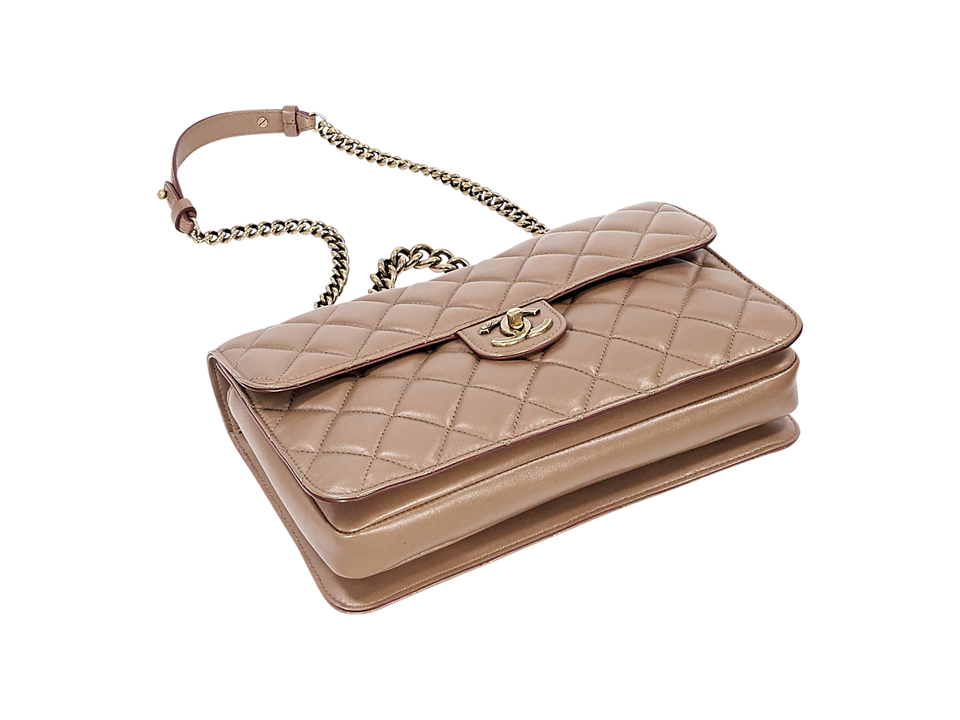 Product details:  Tan quilted leather flap bag by Chanel.  Top chain handle.  Chain and leather shoulder strap.  Twist-lock CC closure on front flap.  Two compartments under both flaps.  Lined interiors with zip pocket.  Goldtone hardware.  12.25