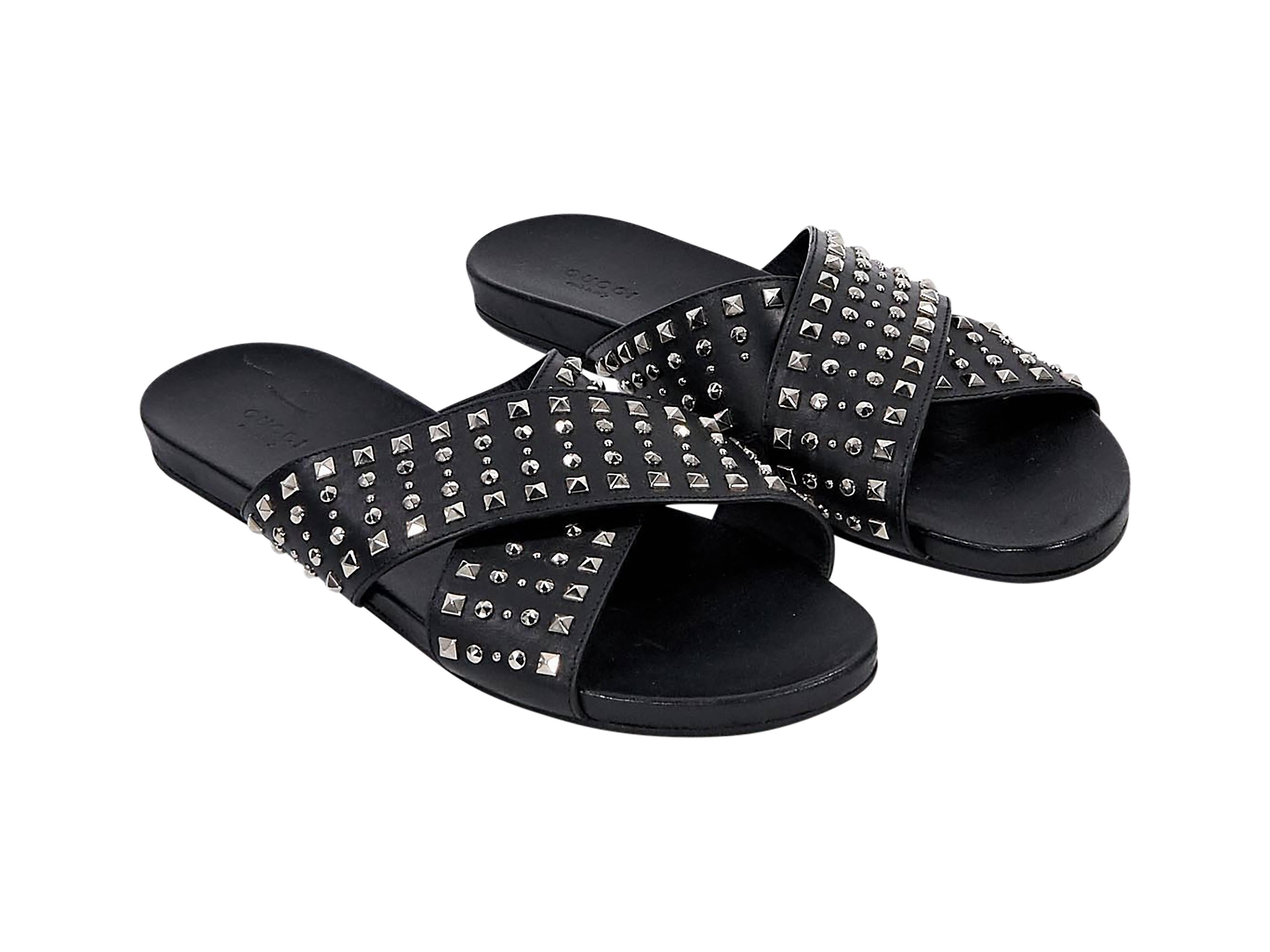 Product details:  Black leather studded slide sandals by Gucci.  Wide crisscross straps.  Open toe.  Slip-on style. 
Condition: Pre-owned. Very good.

Est. Retail $ 425.00