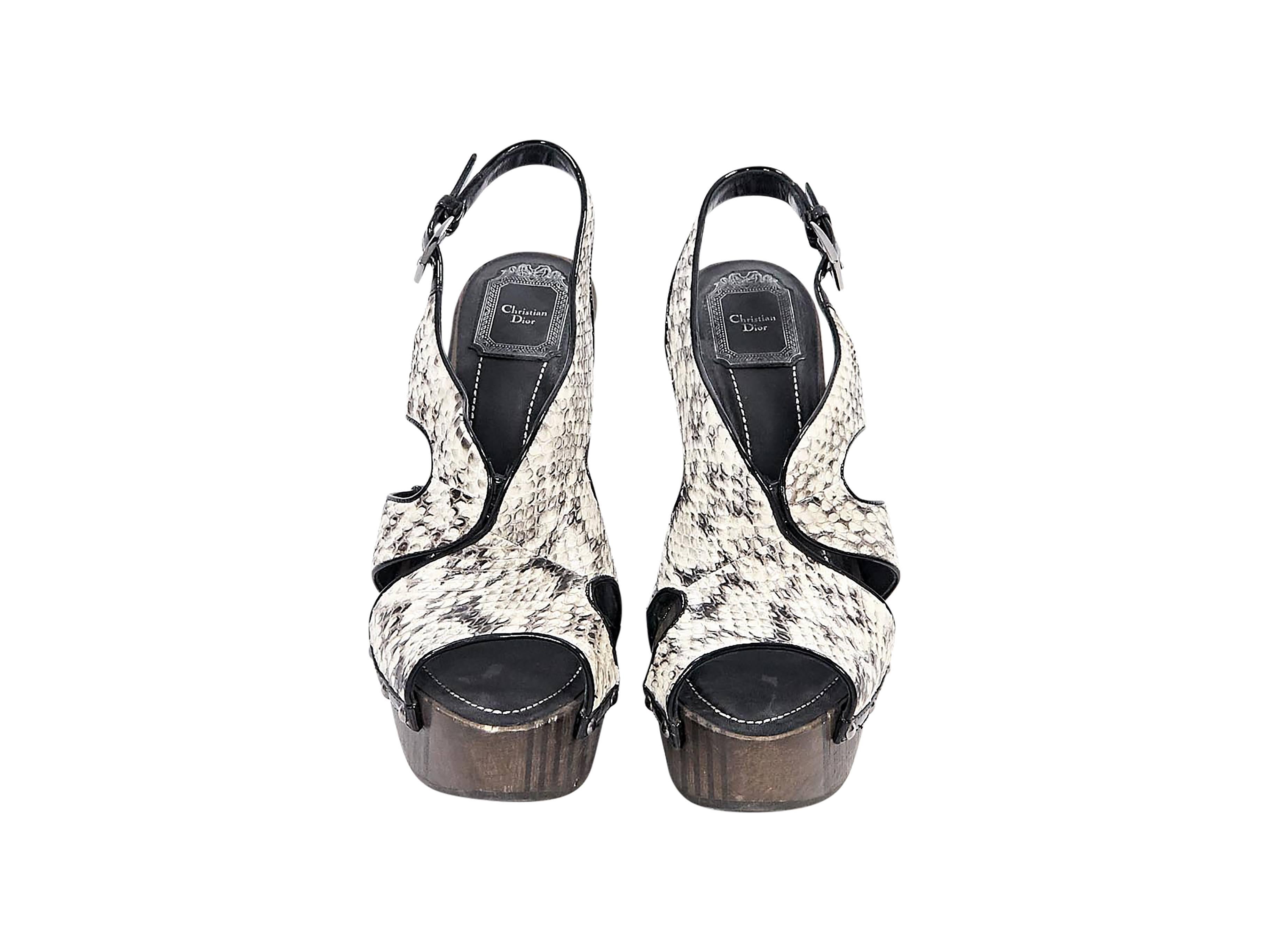 Product details:  White python slingback sandals by Christian Dior.  Adjustable slingback strap.  Open toe.  Wooden conical heel and platform design. 
Condition: Pre-owned. Very good.

Est. Retail $ 925.00