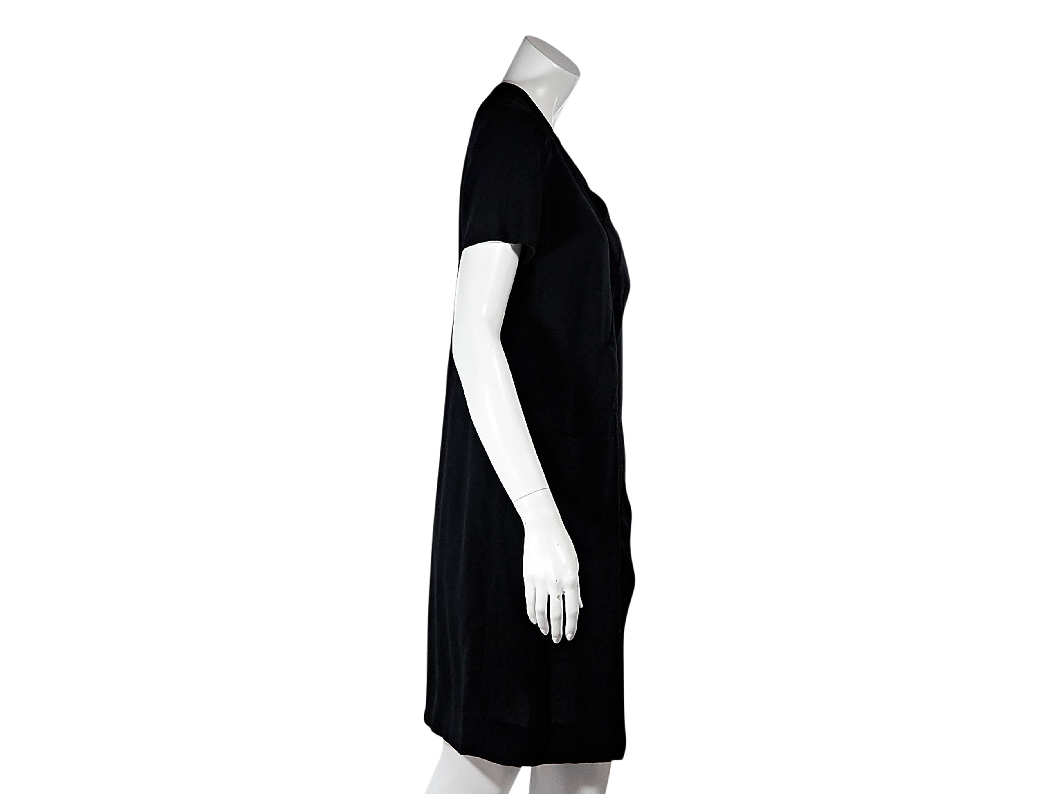 Product details:  Vintage black shift dress by Chanel.  V-neck.  Short sleeves.  Buttons accent shoulder.  Front asymmetrical pleats.  Waist patch pocket.  Concealed back zip closure.  Label size FR 44. 
Condition: Pre-owned. Very good.

