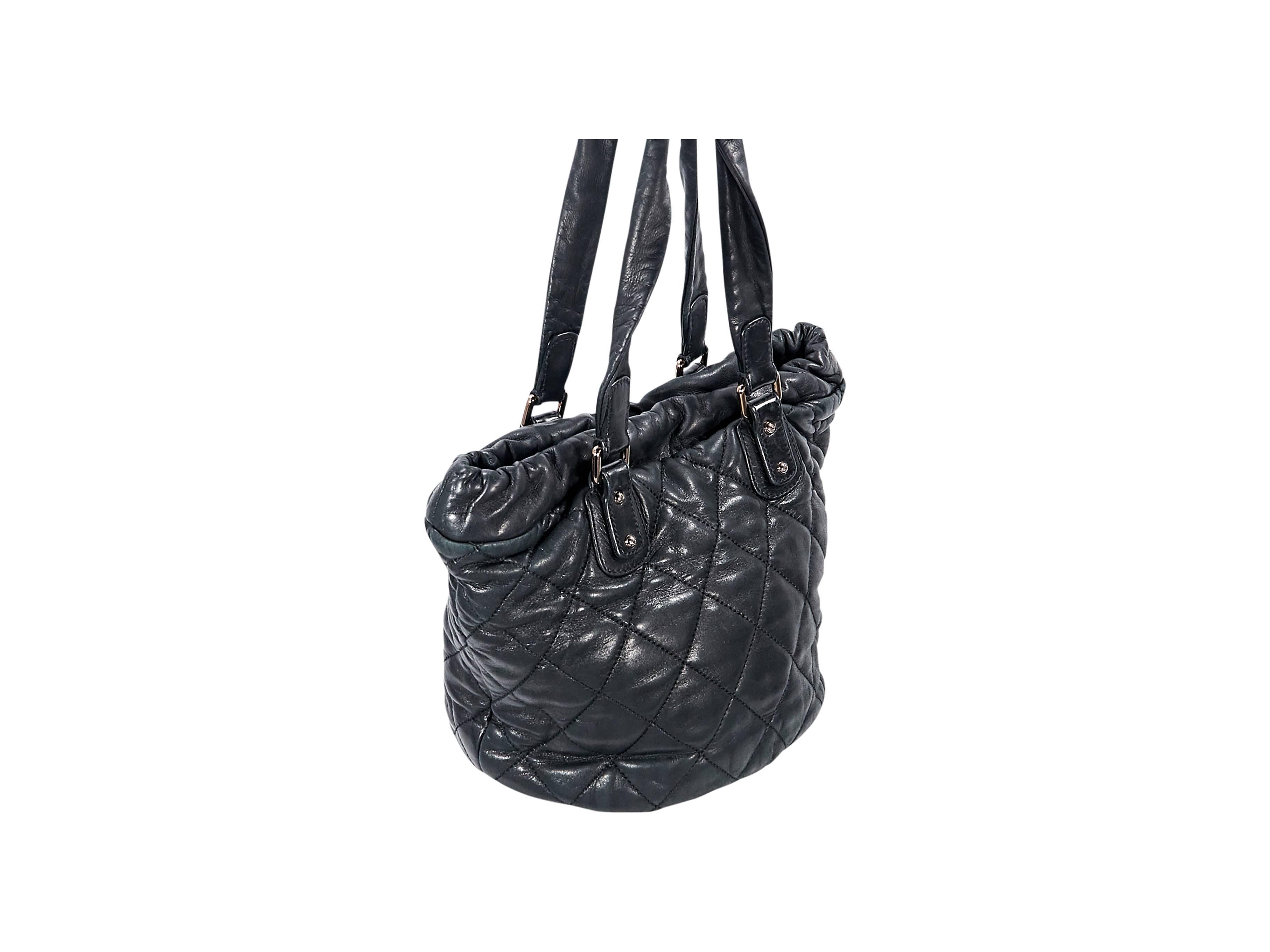 Product details:  Black quilted leather shoulder bag by Chanel.  Dual shoulder straps.  Drawstring top.  Magnetic snap closure.  Lined interior with inner zip and slide pockets.  Goldtone hardware.  15"L x 10"H x 5"D.  8.5"D