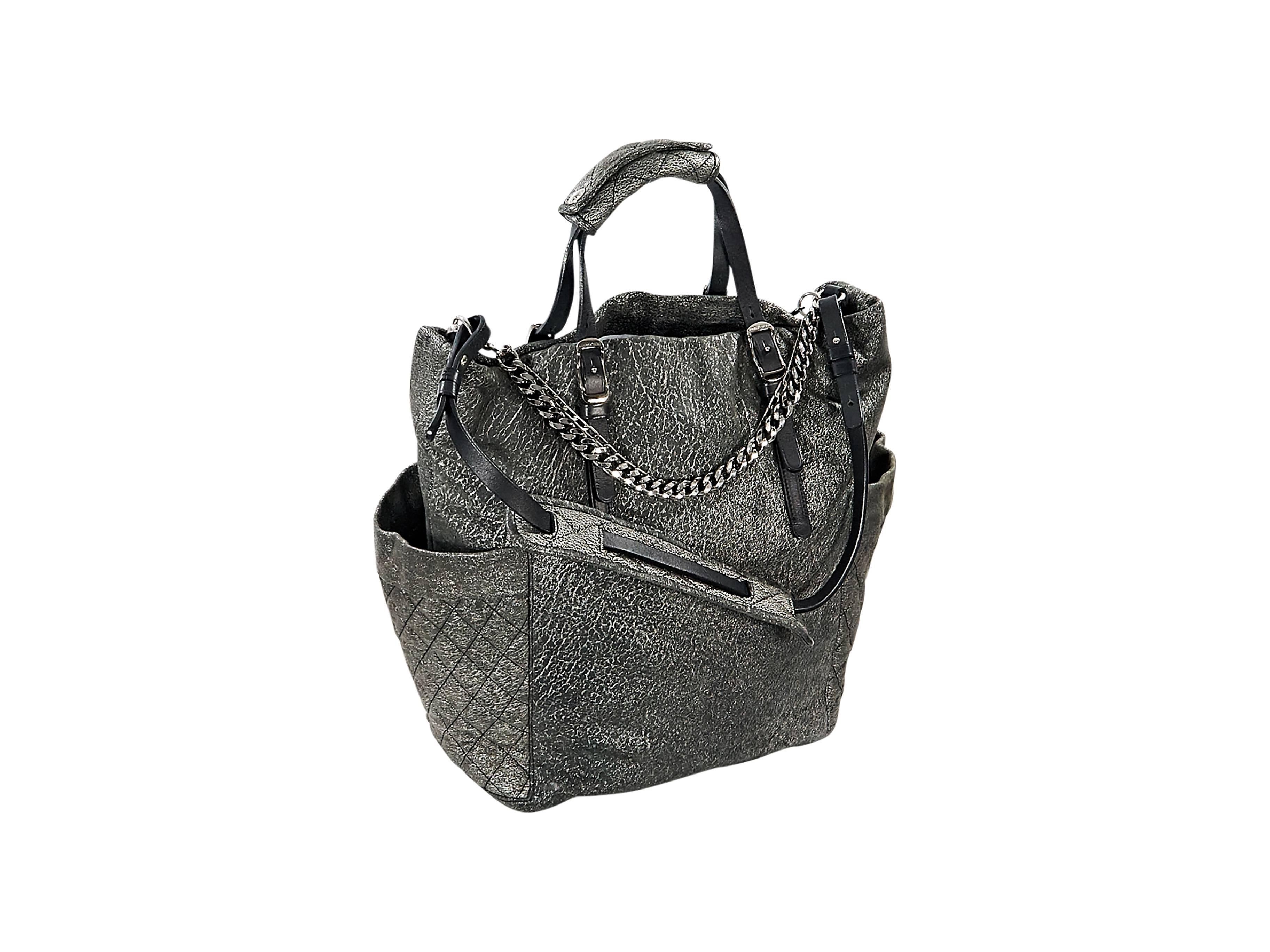 Product details:  Matte silver leather satchel by Jimmy Choo.  Accented with chains.  Top carry handles.  Single shoulder strap.  Side exterior slide quilted pockets.  Lined interior with inner zip and slide pockets.  Silvertone hardware.  15