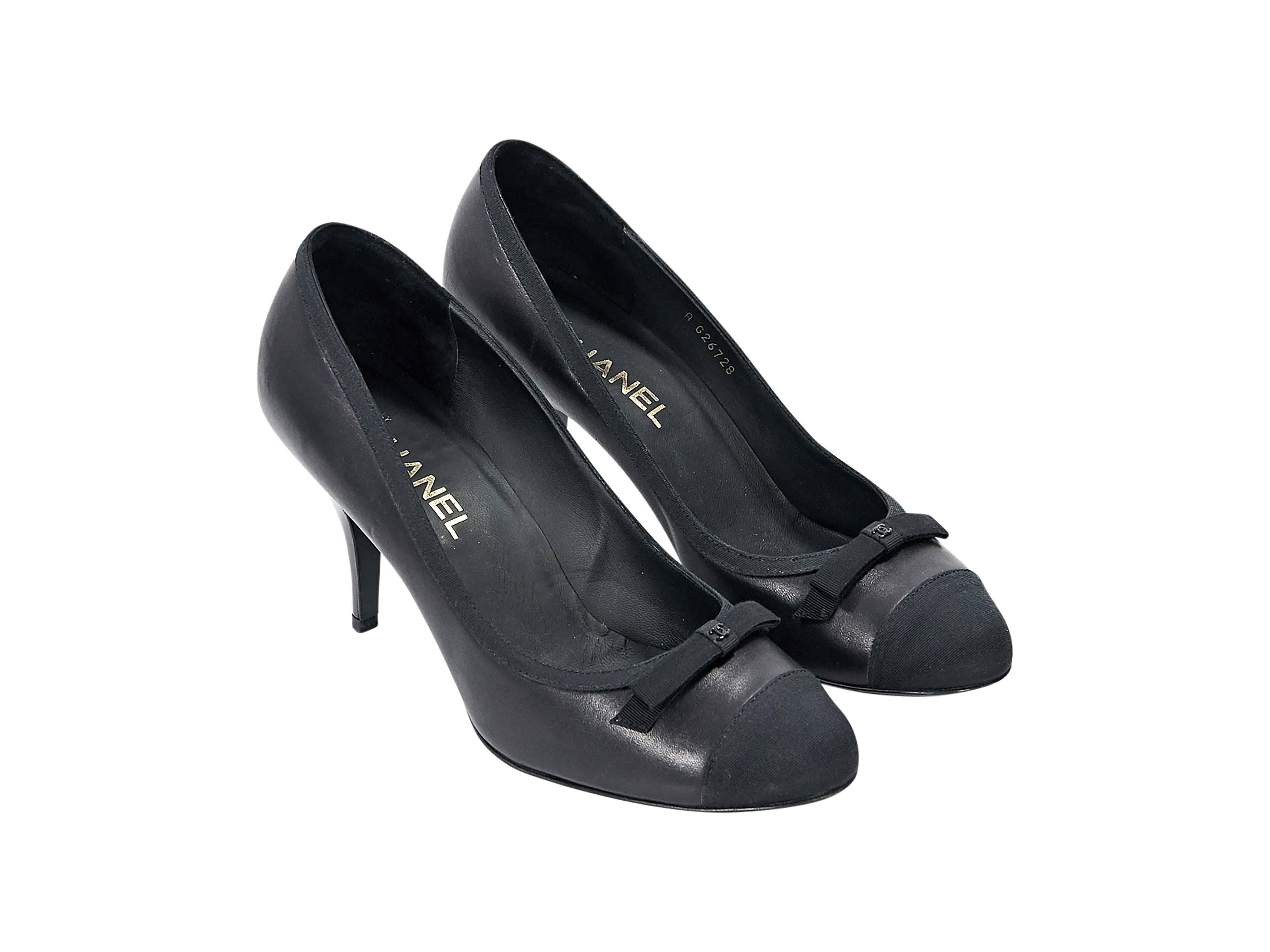 Product details: Black leather pumps by Chanel. Bow accents vamp. Round cap toe. Notched heel. Slip-on style. 
Condition: Pre-owned. Very good.

Est. Retail $ 1,800.00