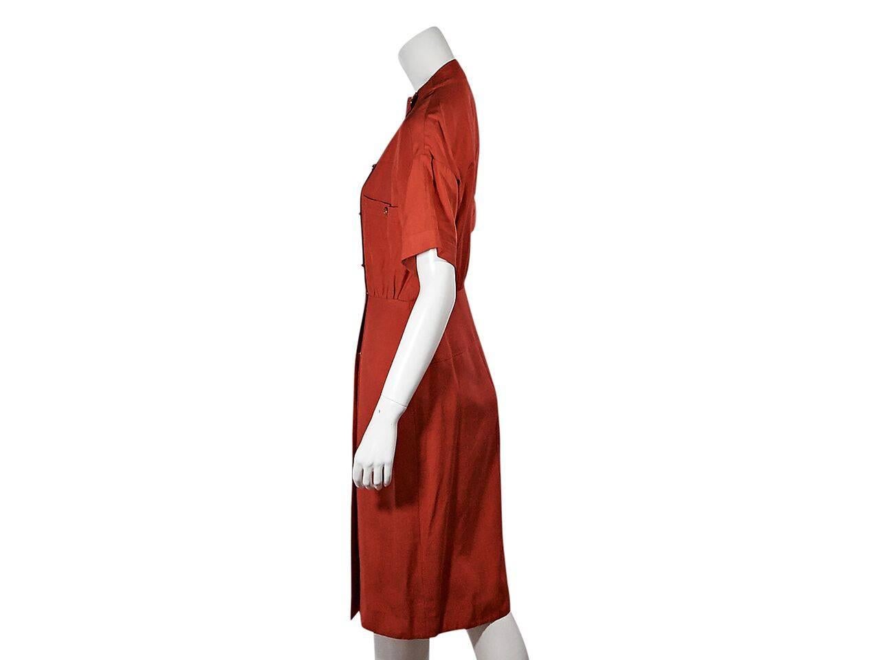 Product details:  Vintage red dress by Chanel.  Banded crewneck.  Short sleeves.  Double breasted closure.  Chest button patch pockets.  Goldtone hardware.  Size M. 
Condition: Pre-owned. Very good.  
Est. Retail $ 1900.00