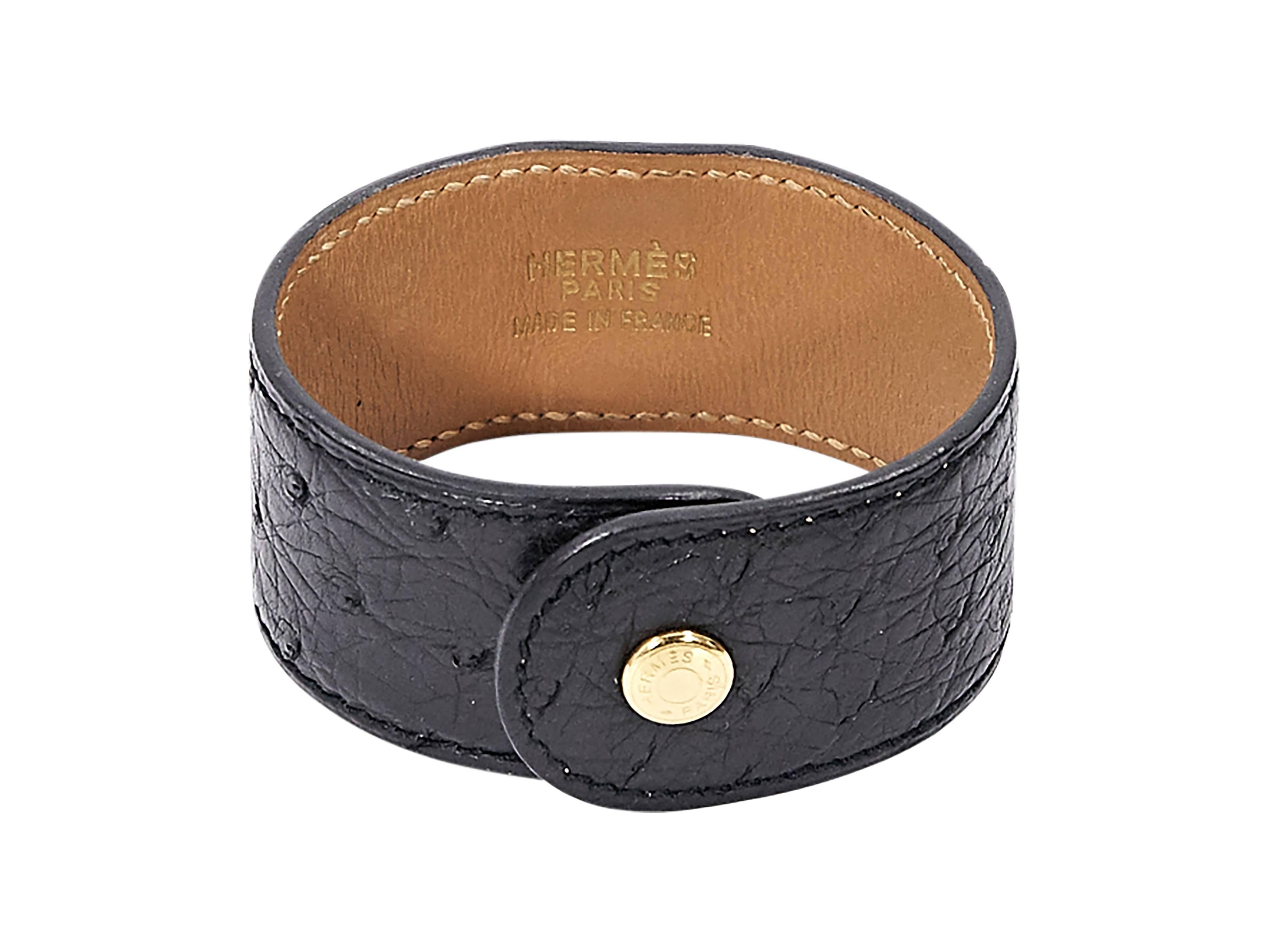 Product details:  Black ostrich Courchevel Medor bracelet by Hermès.  Snap closure.  Goldtone hardware. 
Condition: Pre-owned. Very good.

Est. Retail $ 550.00