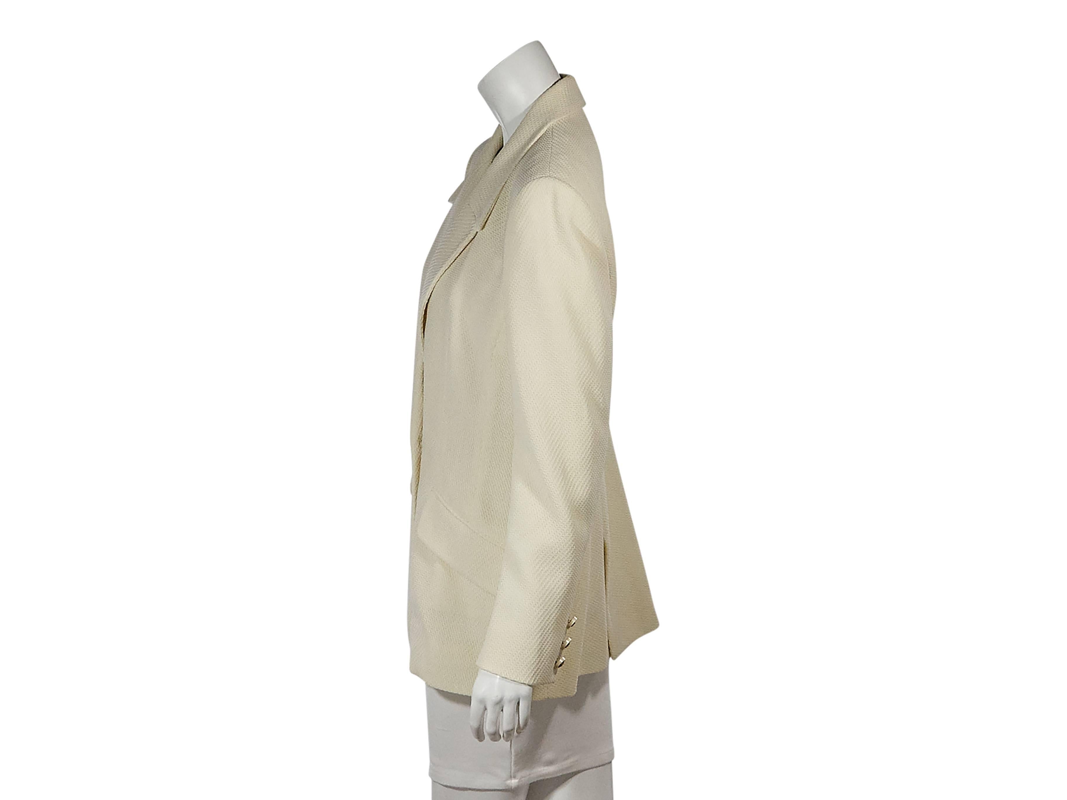 Product details:  Ivory textured blazer by Céline.  Peaked lapel.  Long sleeves.  Triple button detail at cuffs.  Double-breasted closure.  Waist flap pockets.  Double hem vents.  Size 14
Condition: Pre-owned. Very good.

Est. Retail $ 1,200.00