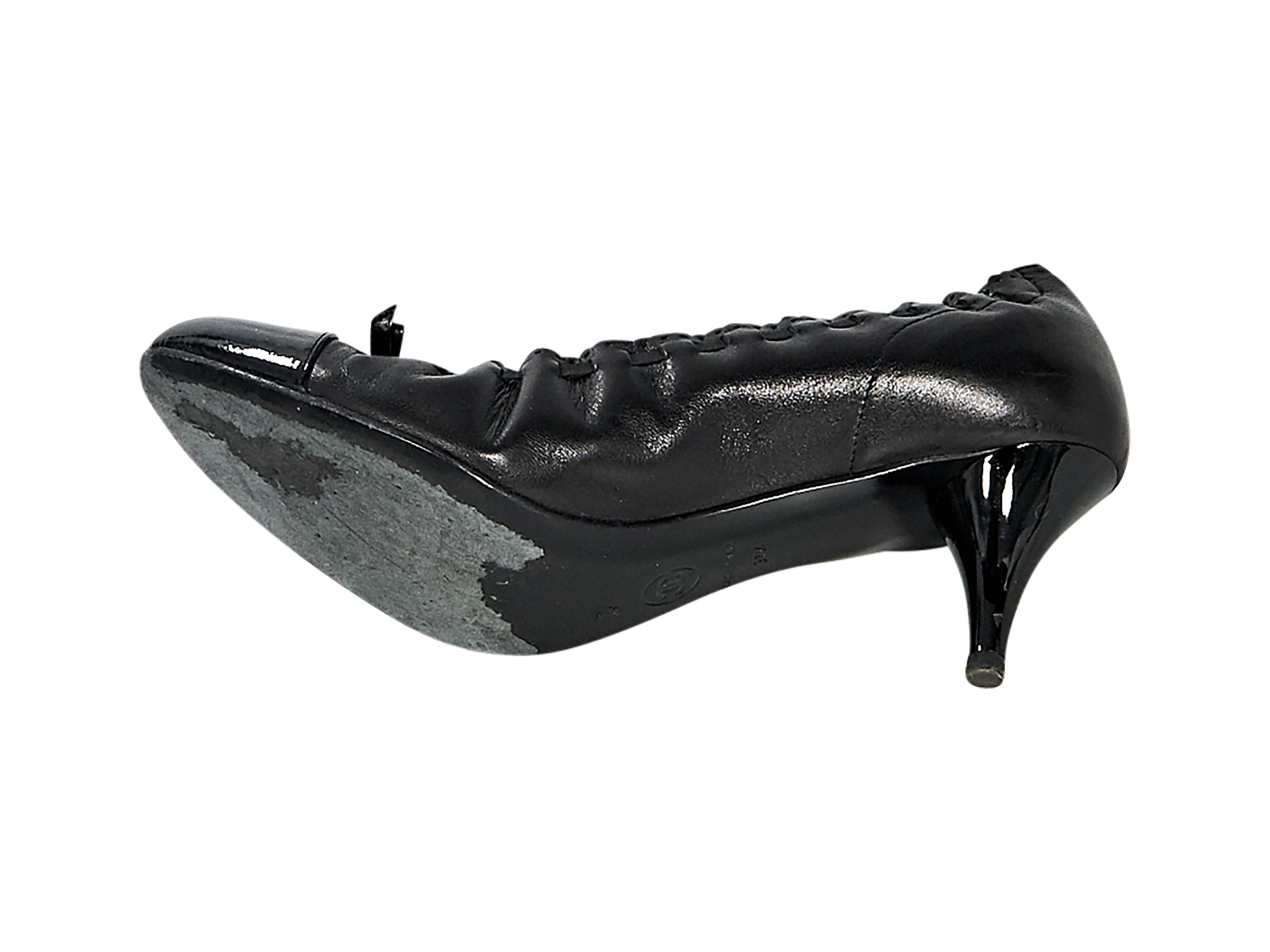 Product details:  Black leather pumps by Chanel.  Cinched top line.  Bow accents vamp.  Round patent leather cap toe.  Slip-on style. Size 7.5
Condition: Pre-owned. Very good.

Est. Retail $ 700.00
