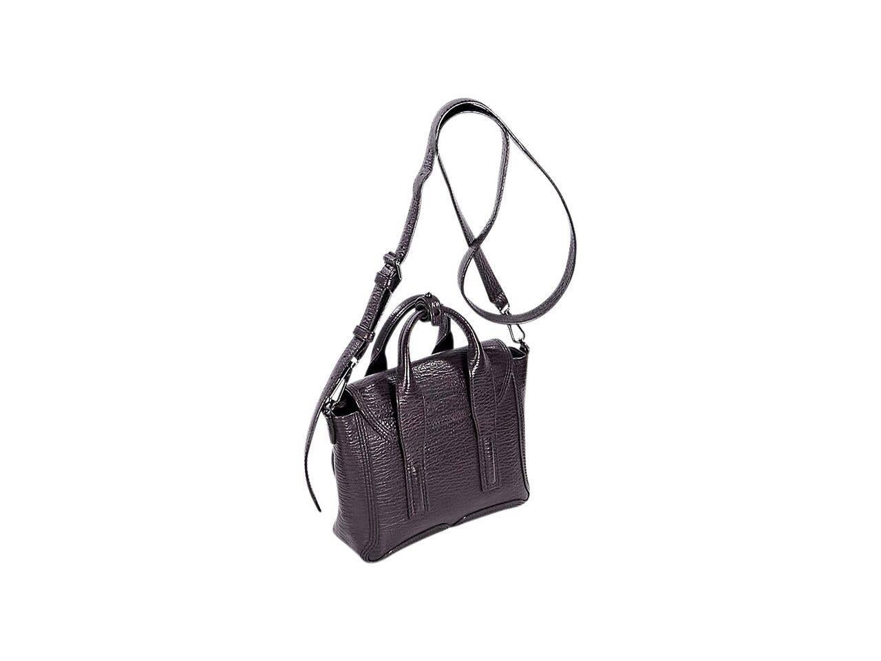 Product details:  Mini eggplant leather Pashli satchel by 3.1 Phillip Lim.  Top carry handles.  Detachable, adjustable crossbody strap.  Front flap with push-lock closure.  Lined interior with inner zip pocket.  Expandable zip sides.  Gunmetal-tone