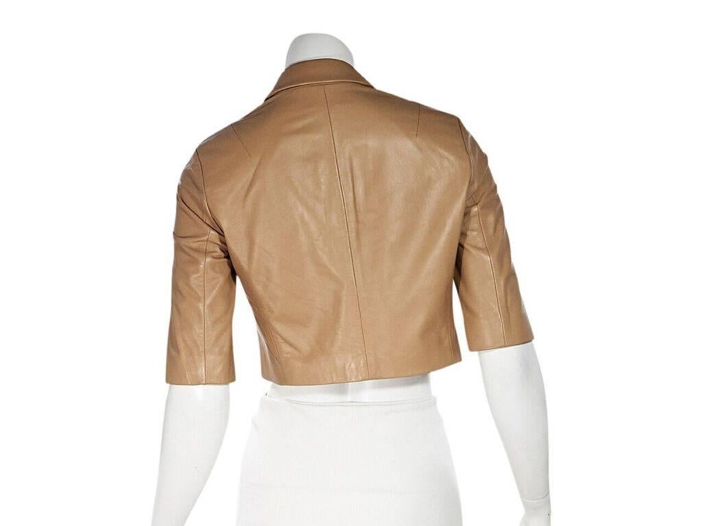 Product details:  Tan cropped leather jacket by Michael Kors Collection.  Rounded peak lapel.  Elbow-length sleeves.  Open front. 
Condition: Pre-owned. Very good.  
Est. Retail $ 798.00