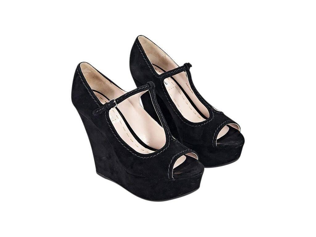 Product details:  Black suede wedge sandals by Miu Miu.  Accented with tonal topstitching.  Adjustable T-strap closure.  Peep toe. 
Condition: Pre-owned. Very good.
Est. Retail $ 630.00