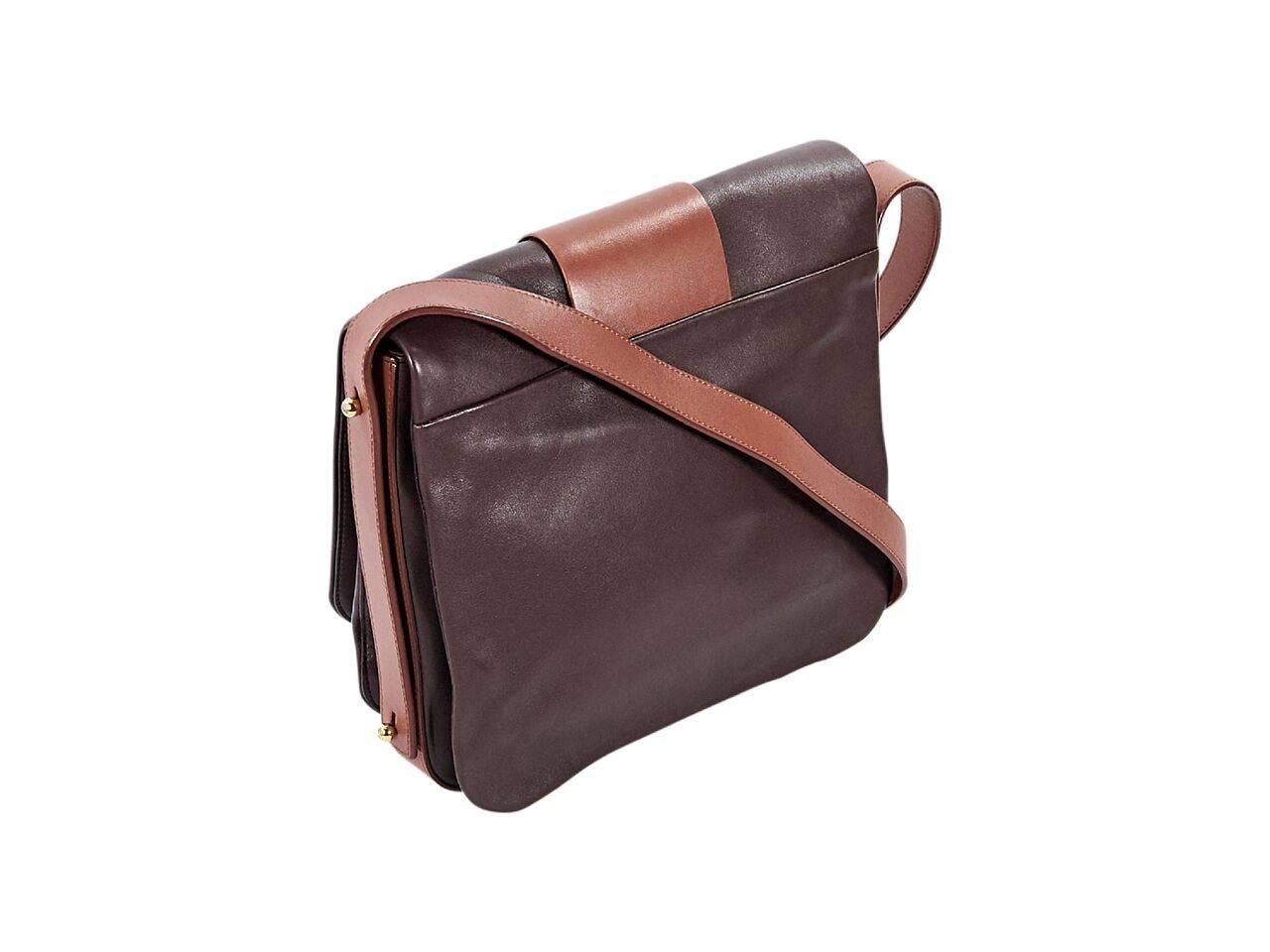 Product details:  Brown and tan leather Black Orchid shoulder bag by Marc Jacobs.  Single shoulder strap.  Front flap with clasp closure.  Leather interior with inner open compartments and inner zip and slide pockets.  Goldtone hardware.  Dust bag