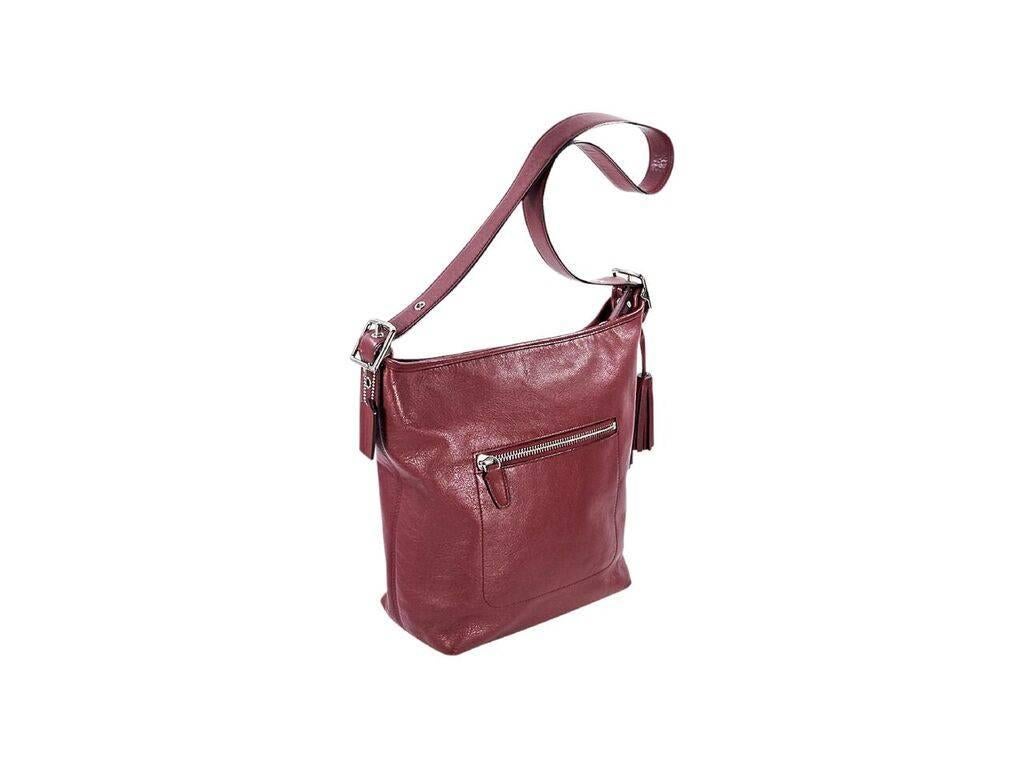 Product details:  Red leather shoulder bag by Coach.  Accented with tassels.  Adjustable single shoulder strap.  Top zip closure.  Lined interior with inner zip and slide pockets.  Back exterior zip pocket.  Silvertone hardware.  12.5