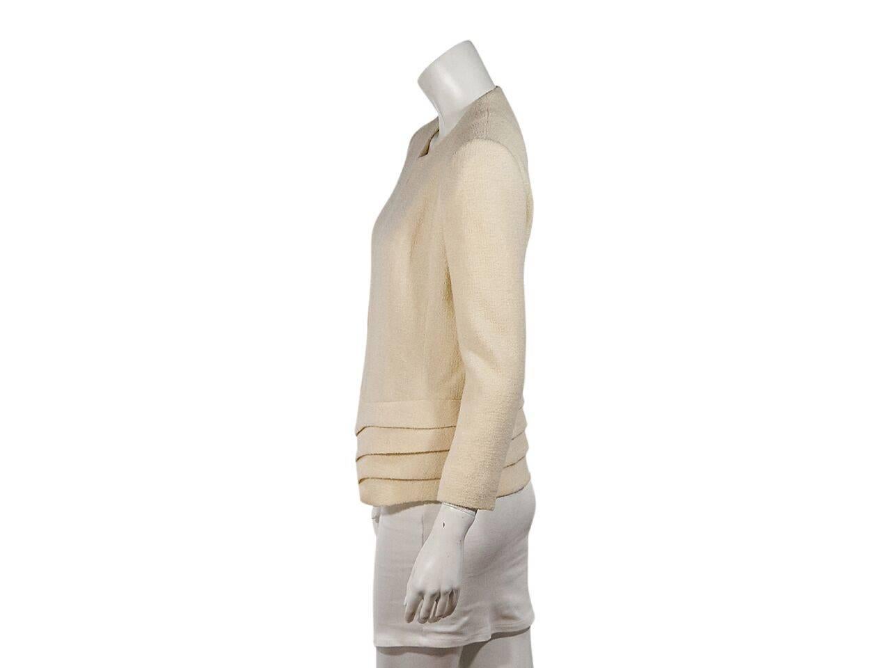 Product details:  Cream textured jacket by Christian Dior.  Crewneck.  Bracelet-length sleeves.  Concealed hook closure.  Pleated hem. 
Condition: Pre-owned. Very good.
Est. Retail $ 998.00