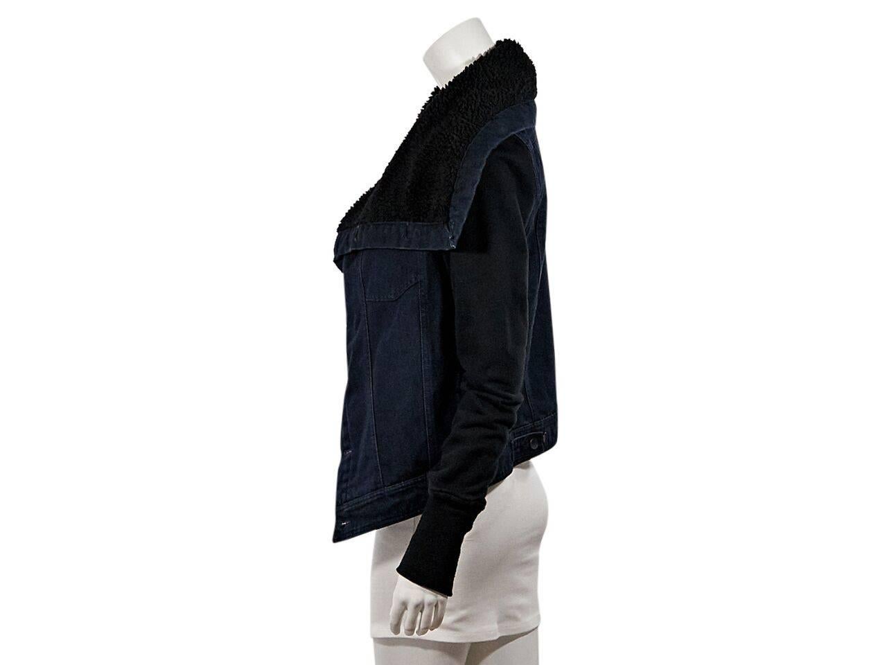 Product details:  Dark blue denim jacket by Oak.  Faux shearling lining.  Draped collar.  Long black sleeves.  Ribbed cuffs.  Button-front closure.  Back hem button tab straps. 
Condition: Pre-owned. Very good.