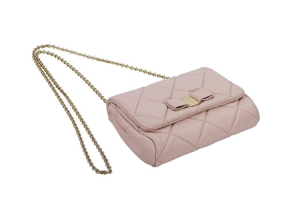 Product details:  Pink quilted leather Vera crossbody bag by Salvatore Ferragamo.  Front flap accented with bow.  Magnetic snap closure.  Lined interior with inner slide pocket.  Goldtone hardware.  9