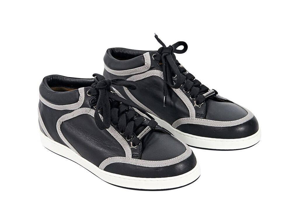 Product details:  Black leather sneakers by Jimmy Choo.  Trimmed with grey grosgrain.  Lace-up closure.  Round toe. 
Condition: Pre-owned. Excellent.
Est. Retail $ 550.00