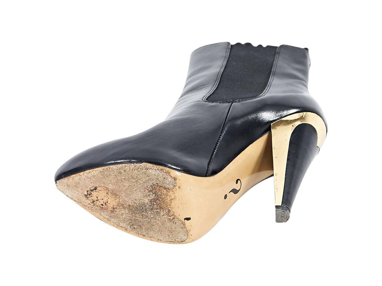 Product details:  Black leather Chelsea ankle boots by Moschino.  Elasticized side panels for an easy fit.  Almond toe.  Metallic gold and black heel.  Concealed platform.  Pull-on style. 
Condition: Pre-owned. Very good.
Est. Retail $ 728.00