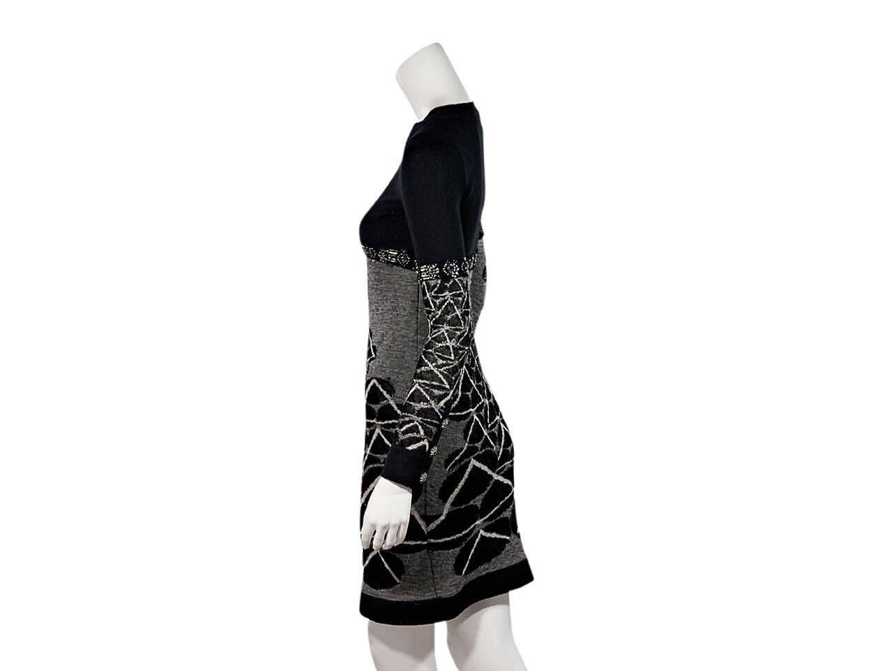 Product details:  Black wool intarsia sweater dress by Chanel.  Ribbed roundneck.  Long sleeves.  Three-button detail at cuffs.  Pullover style. 
Condition: Pre-owned. Very good.
Est. Retail $ 2,925.00