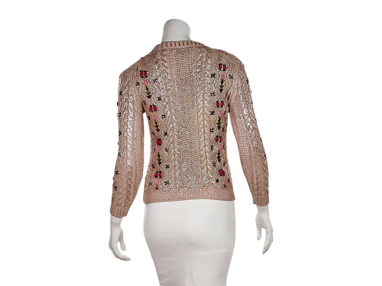 Product details:  Metallic pink cable knit sweater by Gucci.  Accented with multicolor floral embroidery.  Roundneck.  Bracelet-length sleeves.  Ribbed cuffs.  Pullover style. 
Condition: Pre-owned. Very good.
Est. Retail $ 1,295.00