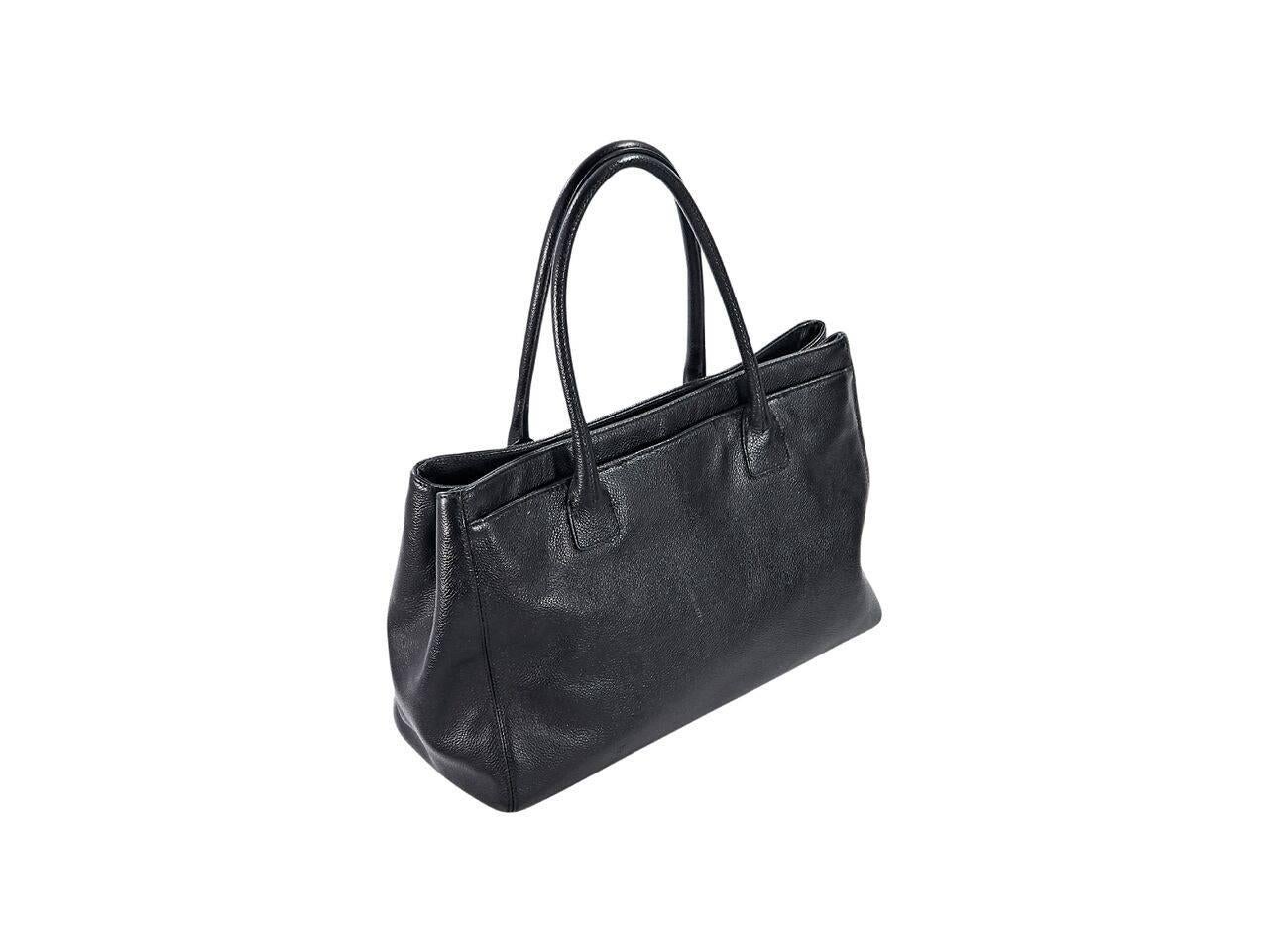 Product details:  Black leather Reissue tote bag by Chanel.  Dual shoulder straps.  Front twist-lock close front compartment.  Double magnetic snap close center compartment.  Lined interiors with inner zip and slide pockets and removable zpouch. 