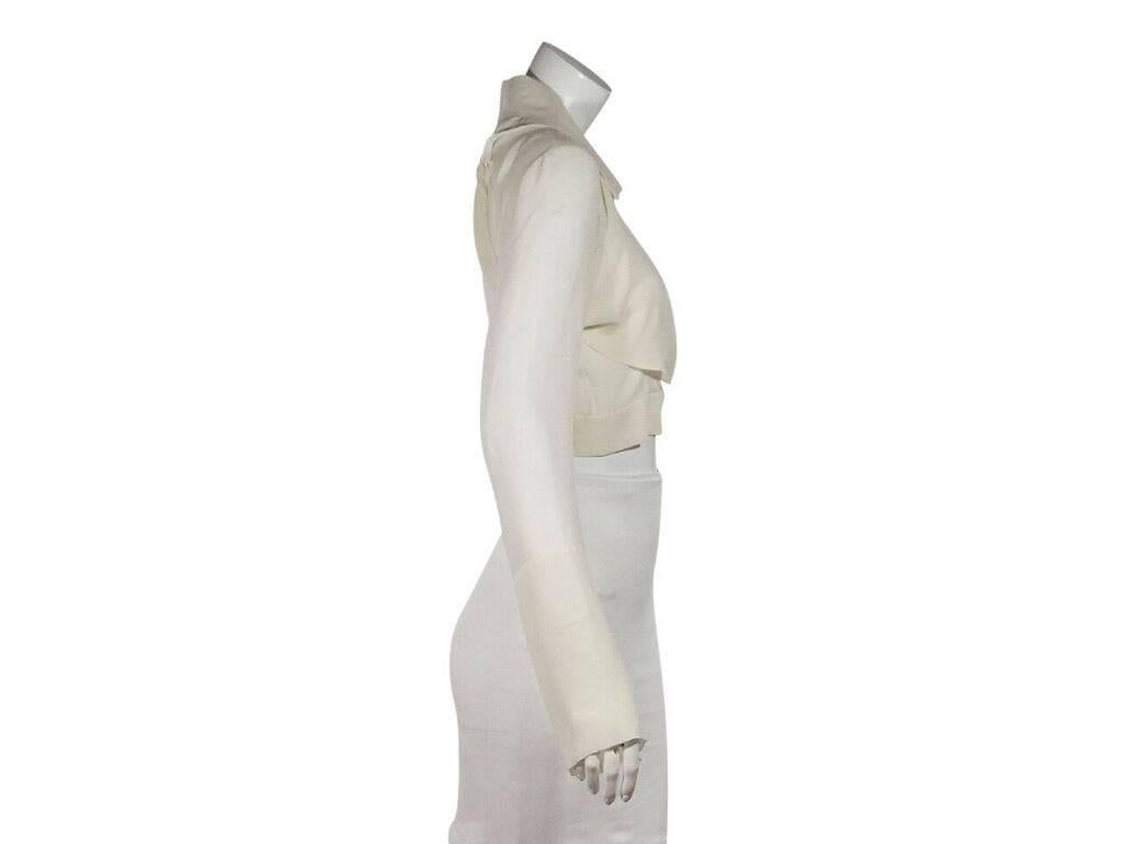 Product details:  Ivory cropped blouse by Chanel.  Side draped detail.  Spread collar.  Long sleeves.  Button-front closure.  Banded hem.  
Condition: Pre-owned. Very good.
Est. Retail $ 1,798.00