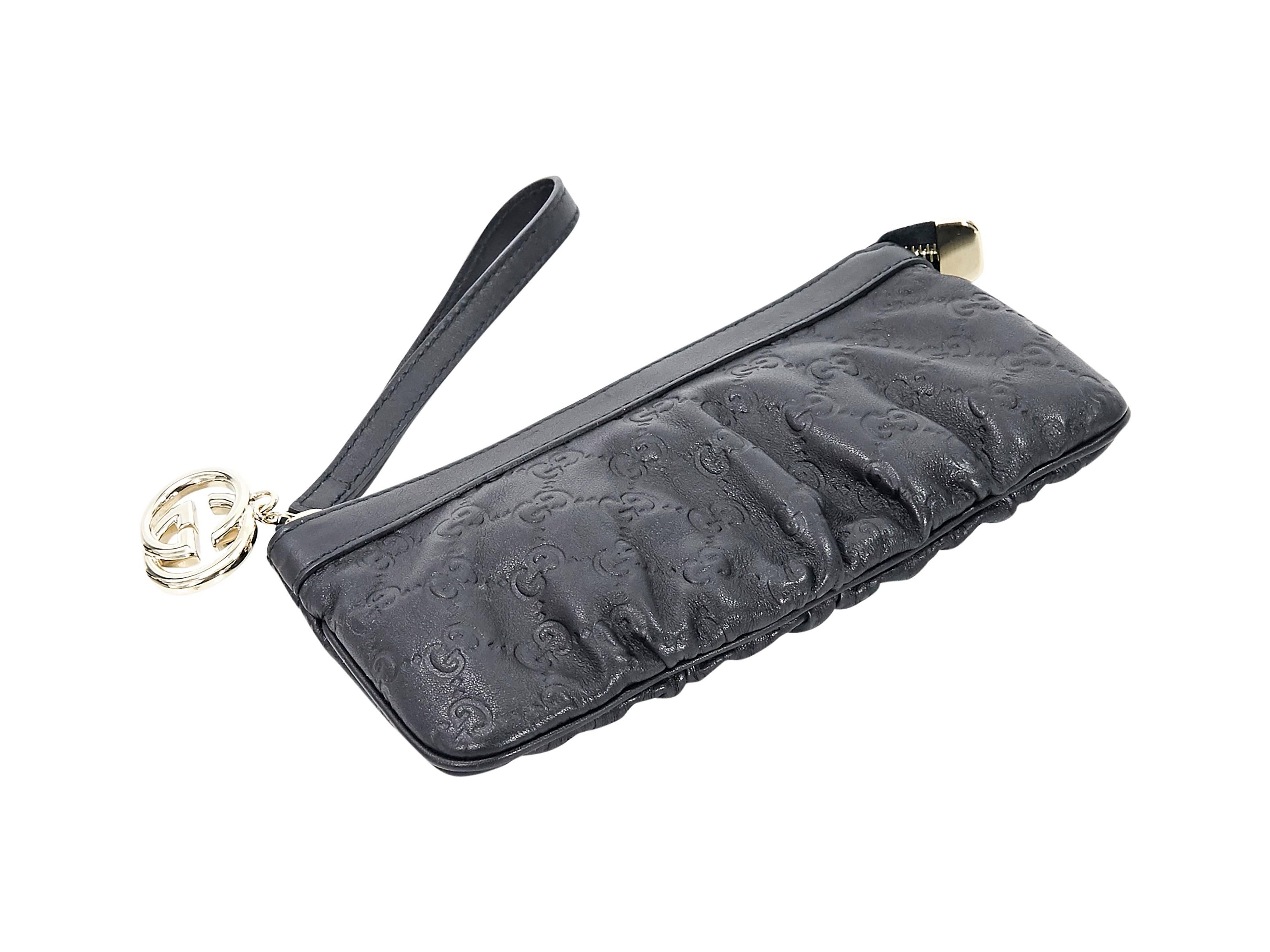 Product details:  Black embossed leather Guccissima wristlet by Gucci.  Wristlet strap.  Top zip closure with logo zipper pull.  Lined interior.  Goldtone hardware.  8.5
