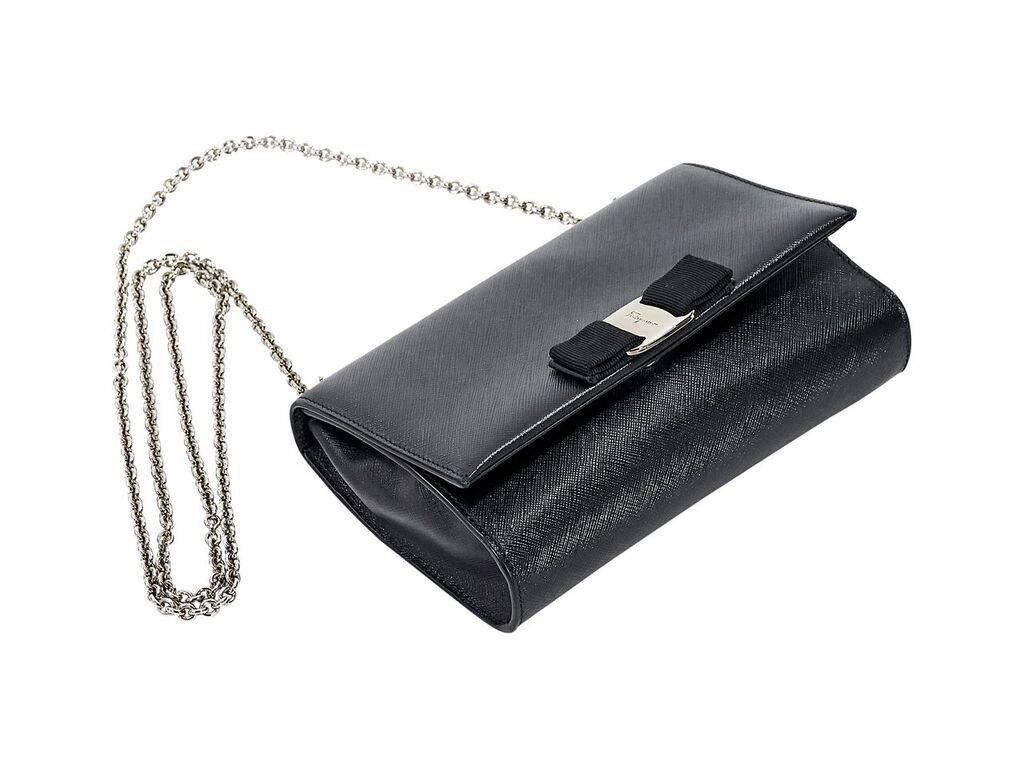 Product details:  Black Vara flap crossbody bag by Salvatore Ferragamo.  Tuck-away chain strap.  Front flap accented with signature grosgrain bow.  Magnetic snap closure.  Goldtone hardware.  7.5