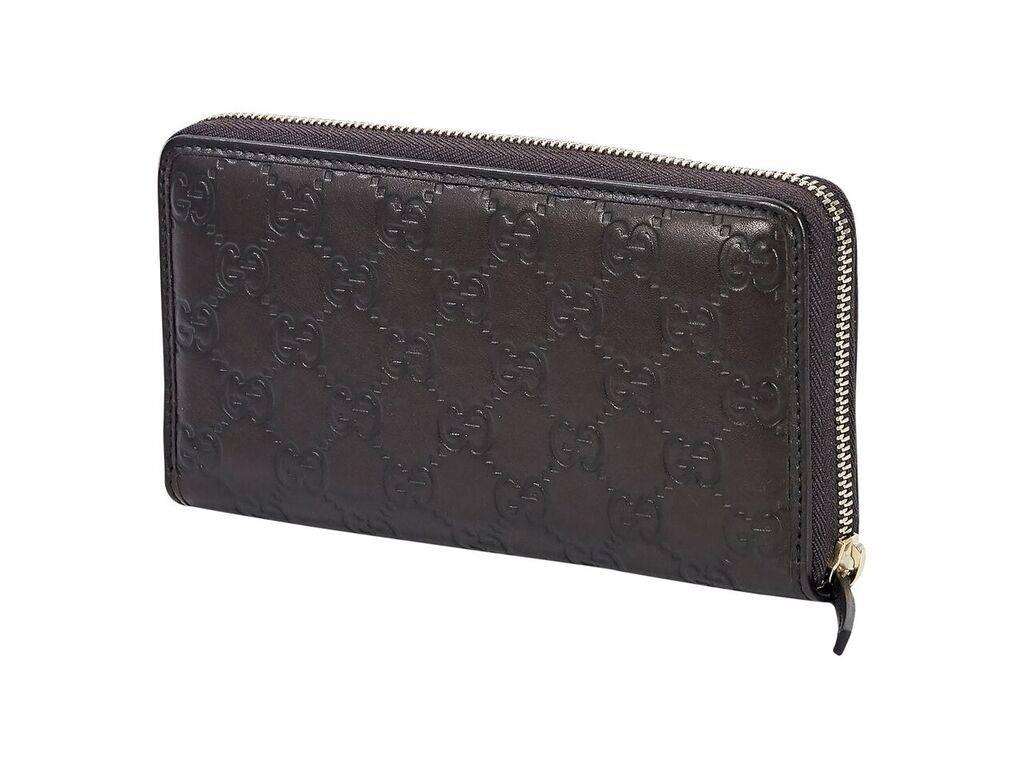 Product details:  Brown logo embossed wallet by Gucci.  Accented with a bow.  Zip-around closure.  Leather interior with multiple credit card slots, zip coin pouch and bill slots.  Goldtone hardware.  7.5"L x 4"H x 1.25"D.  