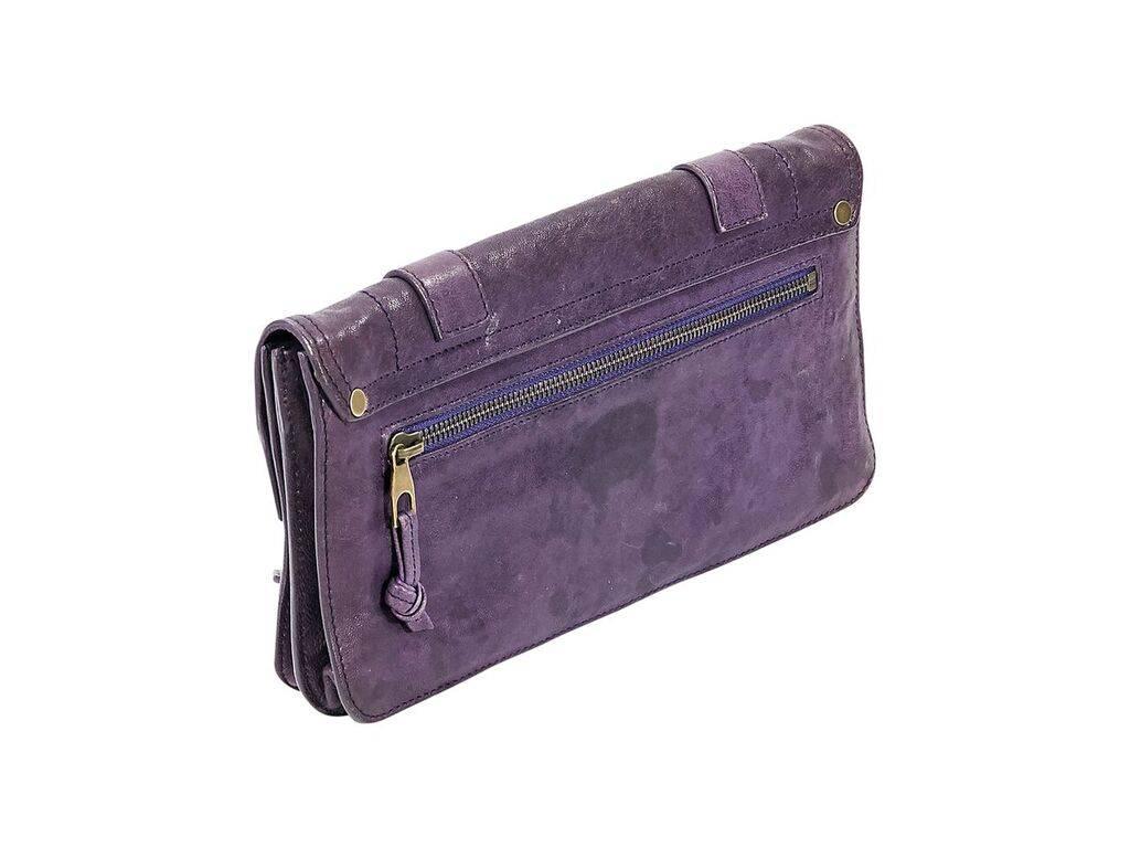Product details:  Purple leather PS1 pochette by Proenza Schouler.  Front flap with double strap accents.  Flip-lock closure.  Leather interior with inner open compartment and zip pocket.  Back zip pocket.  Goldtone hardware.  11"L x 6"H x