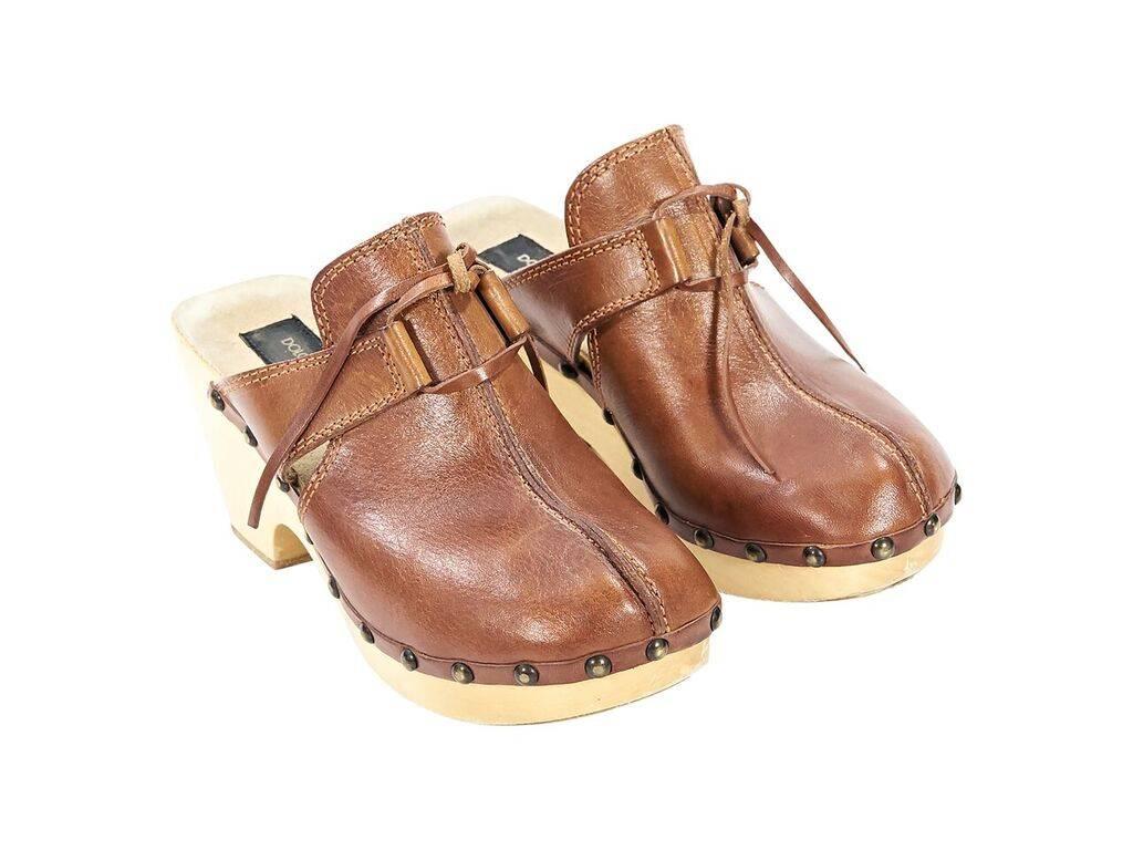 Product details:  Cognac brown leather clogs by Dolce & Gabbana.  Round toe.  Wooden heel.  Slip-on style.  Antique gold-tone hardware. 
Condition: Pre-owned. Very good.
Est. Retail $ 398.00