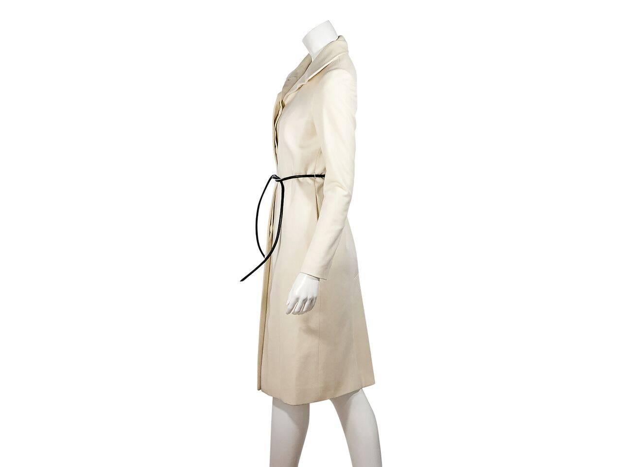 Product details:  Cream wool coat by Gucci.  Spread collar.  Long sleeves.  Concealed button-front closure.  Adjustable tie belted waist.  On-seam waist slide pockets.  Center back hem vent.  Label size IT 42. 
Condition: Pre-owned. Very good.
Est.