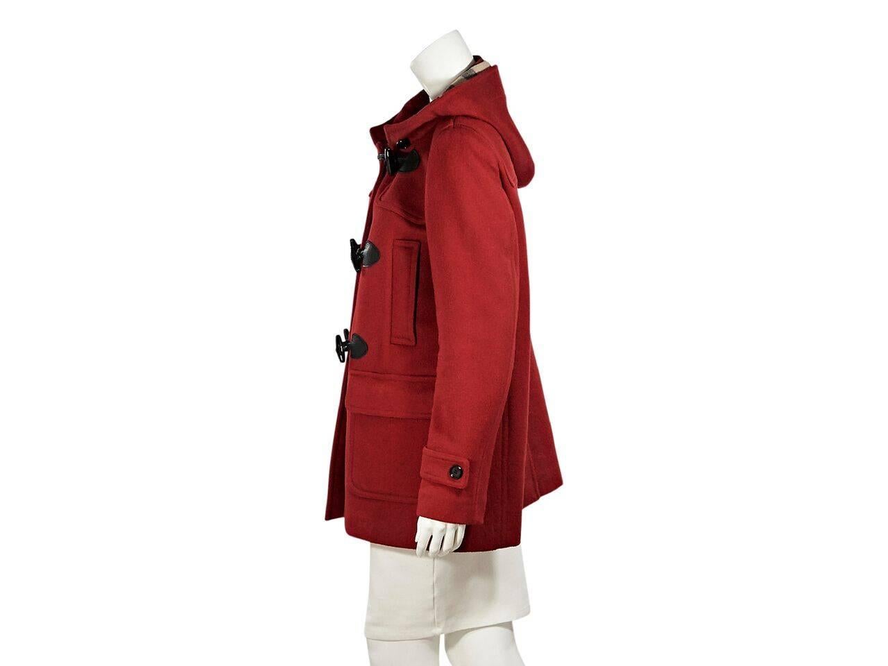 Product details:  Red hooded wool coat by Burberry Brit.  Long sleeves.  Toggle closure.  Chest slide pockets.  Waist flap pockets.  Back center hem vent.  Nova check lining. 
Condition: Pre-owned. Very good.
Est. Retail $ 1,095.00