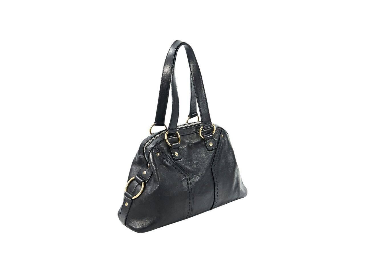 Product details:  Black leather Muse tote bag by Yves Saint Laurent.  Dual shoulder straps.  Top zip closure.  Lined interior with inner zip and slide pockets.  Protective metal feet.  Goldtone hardware.  13.25