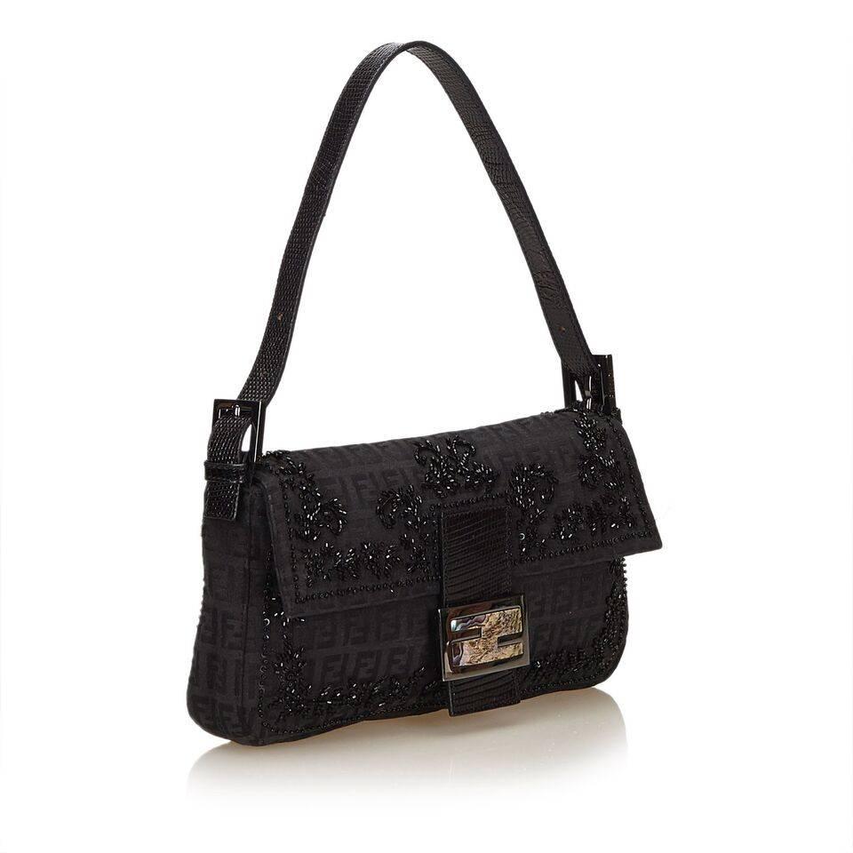Product details:  Black Zucchino jacquard baguette bag by Fendi.  Embellished with beads.  Single shoulder strap.  Front flap with magnetic snap closure.  Lined interior with inner zip pocket.  Silvertone hardware.  Dust bag included.  10
