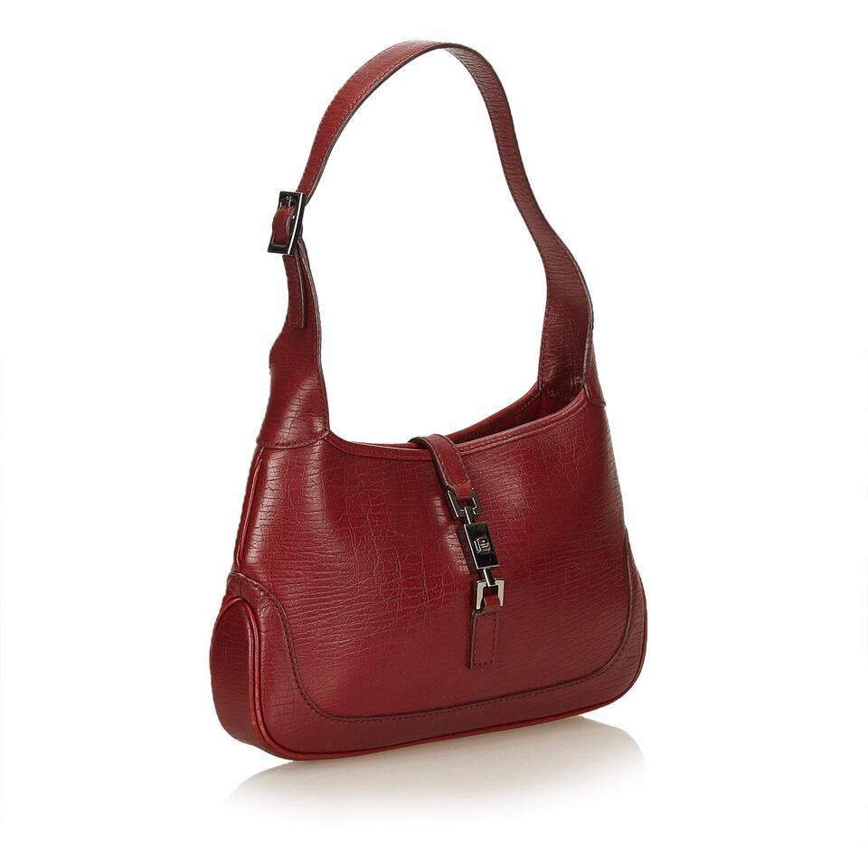 Product details:  Red leather shoulder bag by Gucci.  Adjustable single shoulder strap.  Top push-lock strap closure.  Lined interior with inner zip pocket.  Silvertone hardware.  Dust bag included.  11