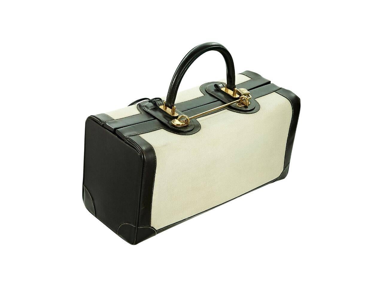 Product details:  Vintage tan canvas hand trunk by Hermes.  Trimmed with brown leather.  Top carry handle.  Lock and key closure.  Lined interior with inner zip and slide pockets.  Protective metal feet.  Goldtone hardware.  16.75"L x