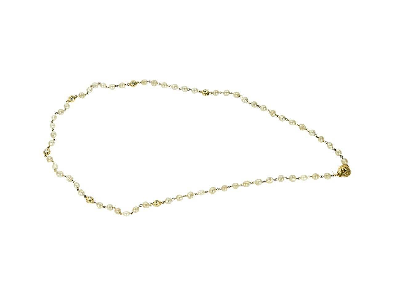 Product details:  Vintage goldtone faux pearl necklace by Chanel.  Single strand design that can be wrapped.  Accented with logo and crystal charms.  36