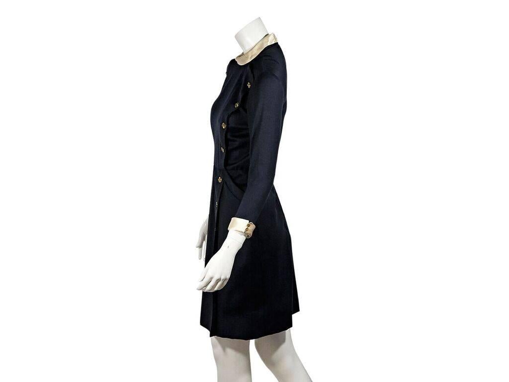 Product details:  Vintage navy blue double-breasted dress by Chanel.  Round foldover collar.  Three-quarter length sleeves.  Double-button detail at cuffs.  Concealed back zip closure.  Goldtone hardware.
Condition: Pre-owned. Very good.
Est. Retail
