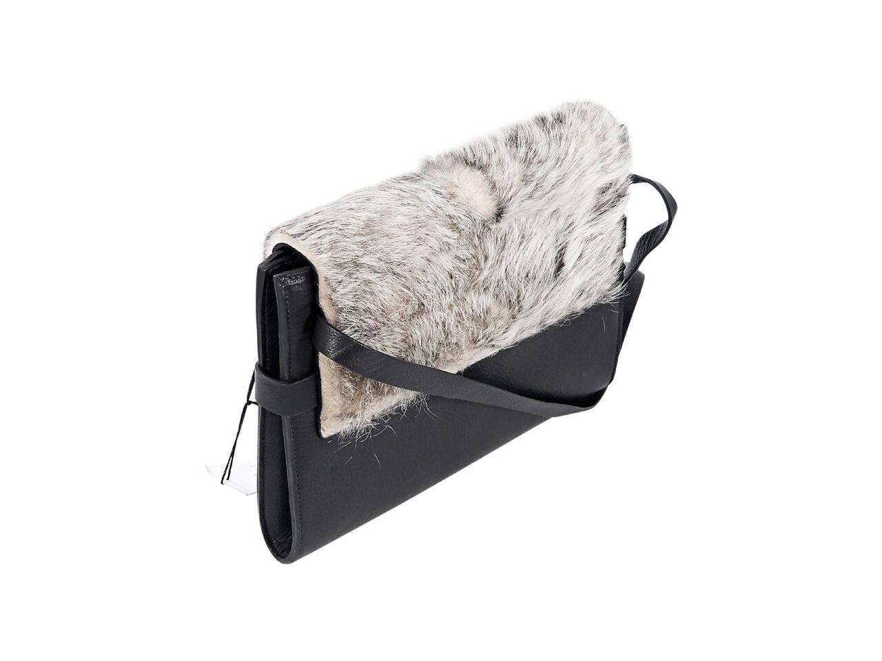 Product details:  Grey shearling fur and leather Ima shoulder bag by Zero + Maria Cornejo.  Adjustable shoulder strap.  Front flap.  Lined interior with inner zip pocket.  Side tab straps.  Black hardware.  11.5