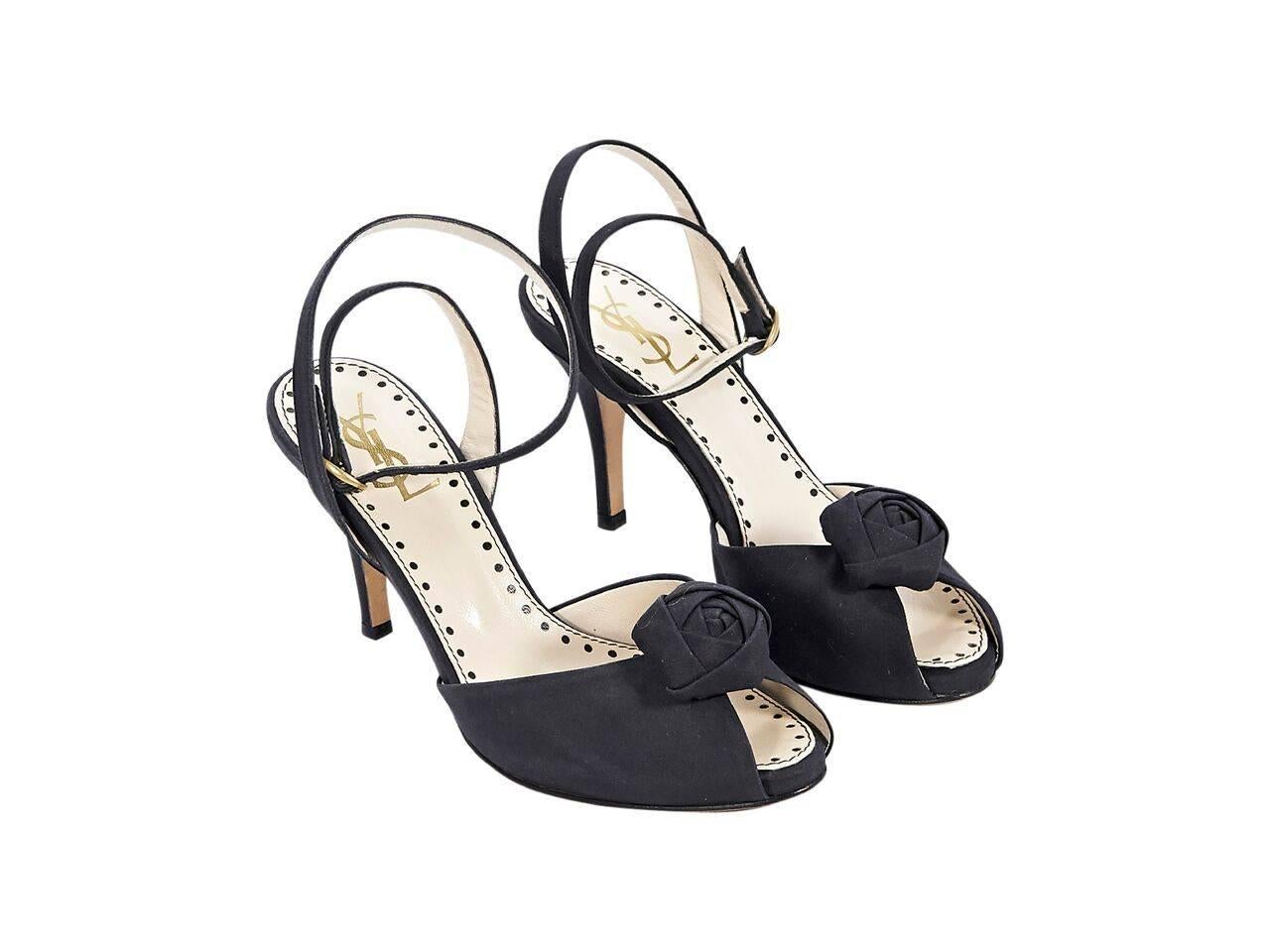 Product details:  Black satin pumps by Yves Saint Laurent.  Adjustable ankle strap.  Rosette accents vamp.  Peep toe.  
Condition: Pre-owned. Very good.
Est. Retail $ 648.00