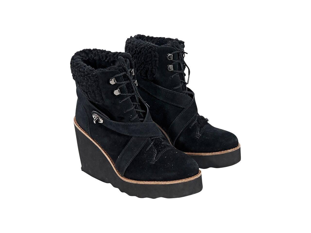 Product details:  Black suede wedge ankle boots by Coach.  Trimmed with shearling detail.  Crisscross instep buckle straps with twist-lock closure.  Lace-up front.  Round toe.  Silvertone hardware.
Condition: Pre-owned. Very good.
Est. Retail $